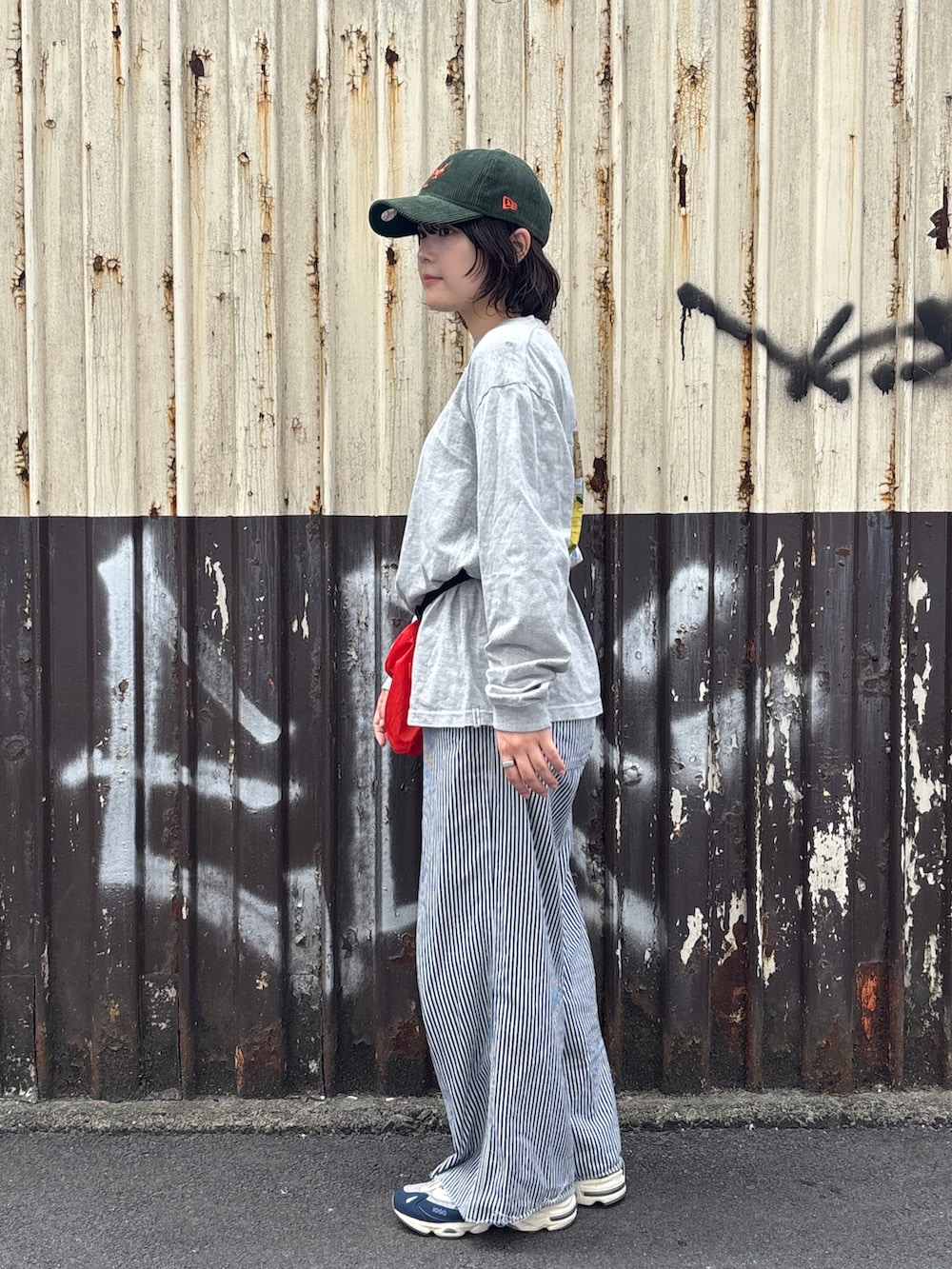 レッド系のボディバッグ/ウエストポーチ、その他のその他パンツ、ブルー系のスニーカーを着用したレディースの秋コーディネートの2枚目の写真
