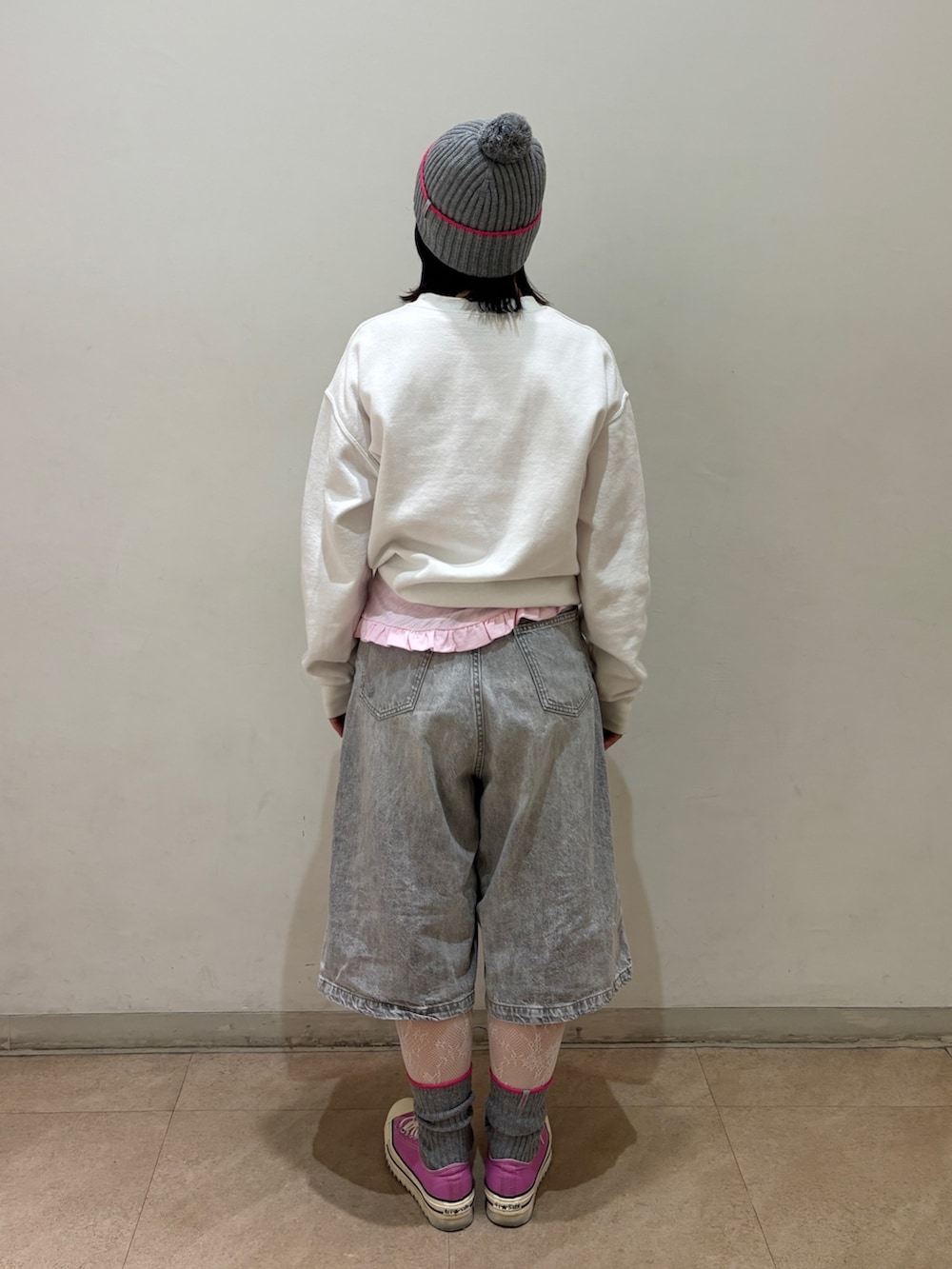 ピンク系のTシャツ/カットソー、グレー系のデニムパンツ、ピンク系のスニーカーを着用したレディースの秋コーディネートの3枚目の写真