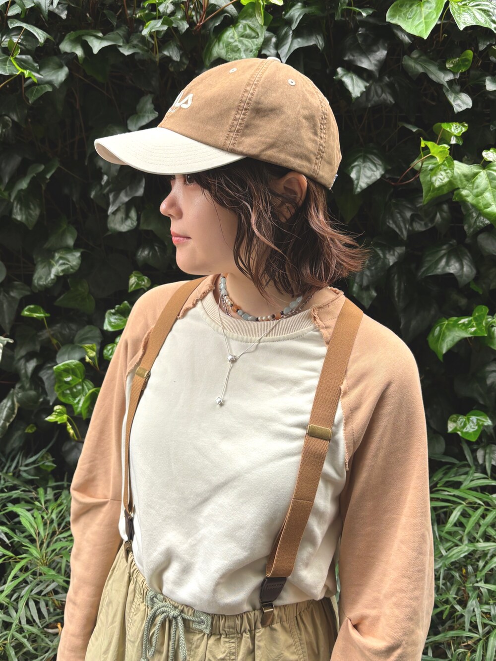 ベージュ系のTシャツ/カットソー、ベージュ系のその他パンツ、ブラウン系のキャップを着用したレディースの春コーディネートの4枚目の写真