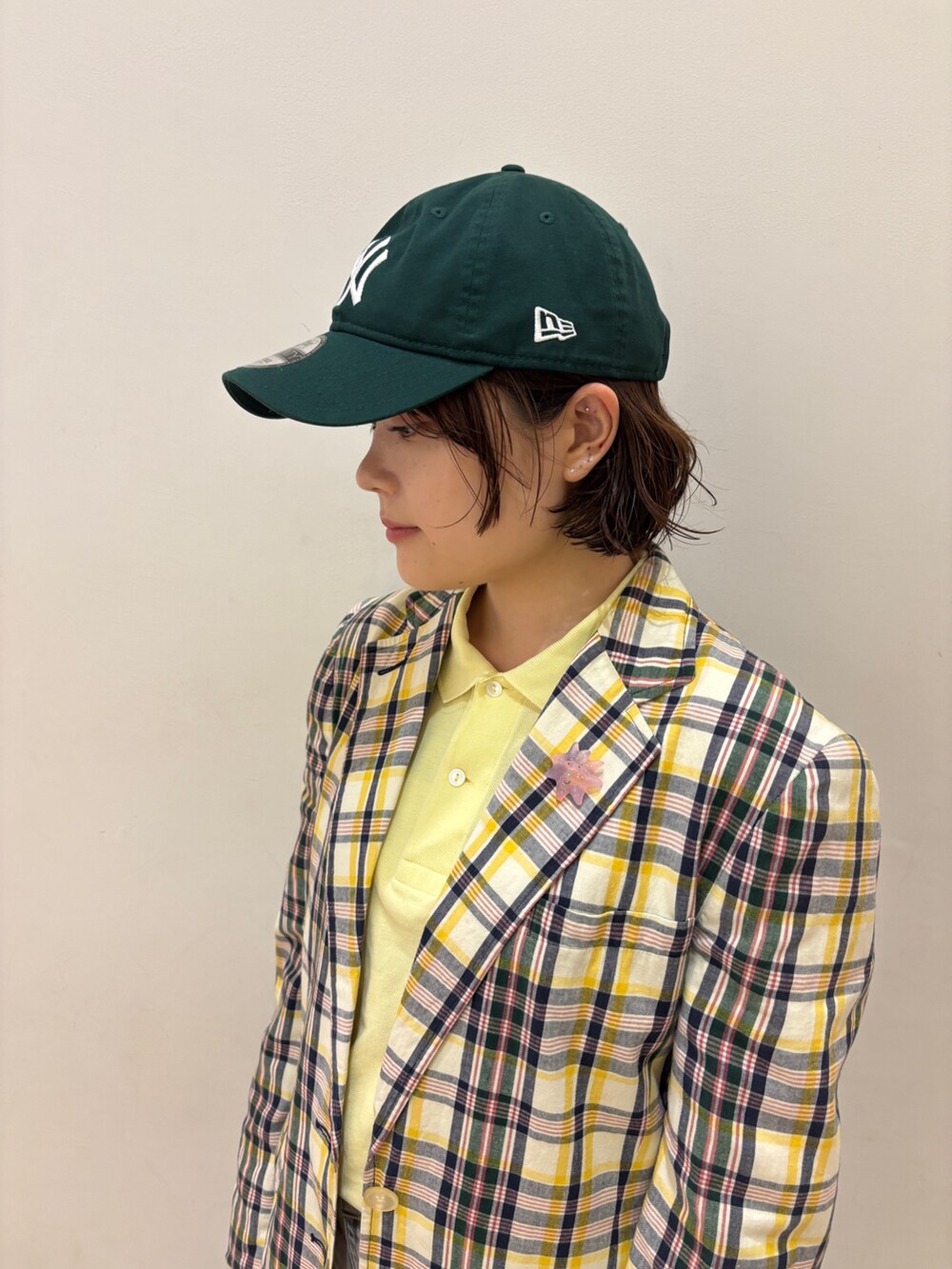 グレー系のデニムパンツ、グリーン系のキャップを着用したレディースの夏コーディネートの4枚目の写真