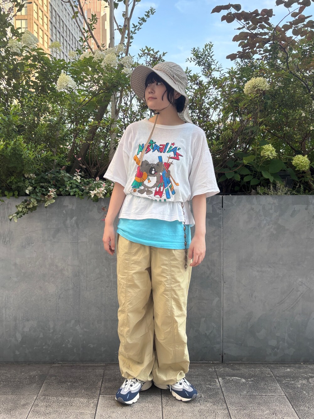 ブルー系のスニーカー、ベージュ系のハットを着用したレディースの夏コーディネートの2枚目の写真