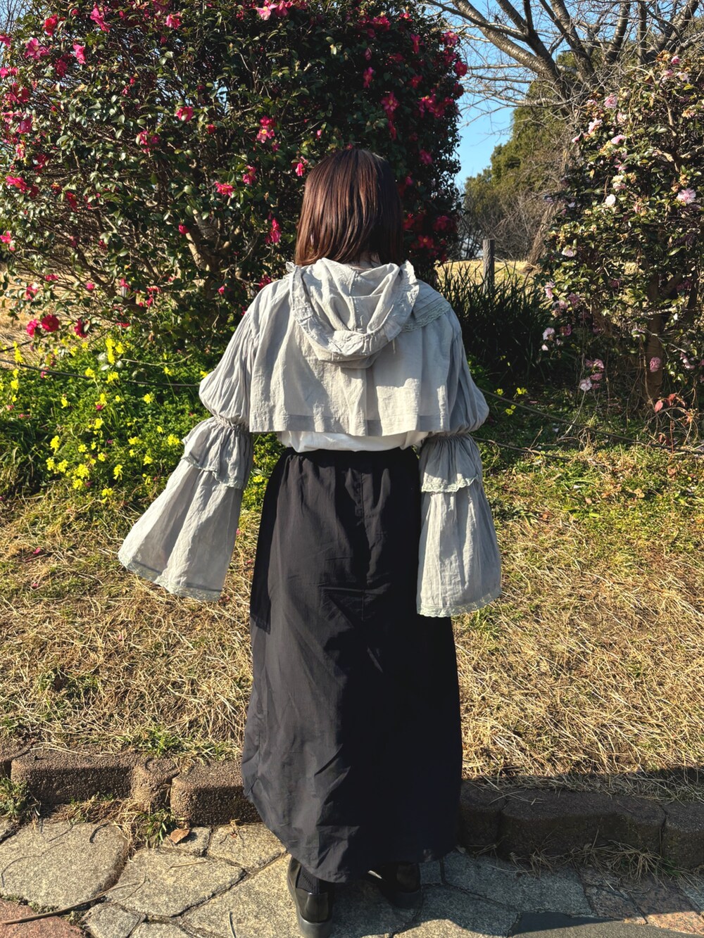 グレー系のシャツ/ブラウス、ブラック系のスカート、ブラック系のスニーカーを着用したレディースの冬コーディネートの3枚目の写真