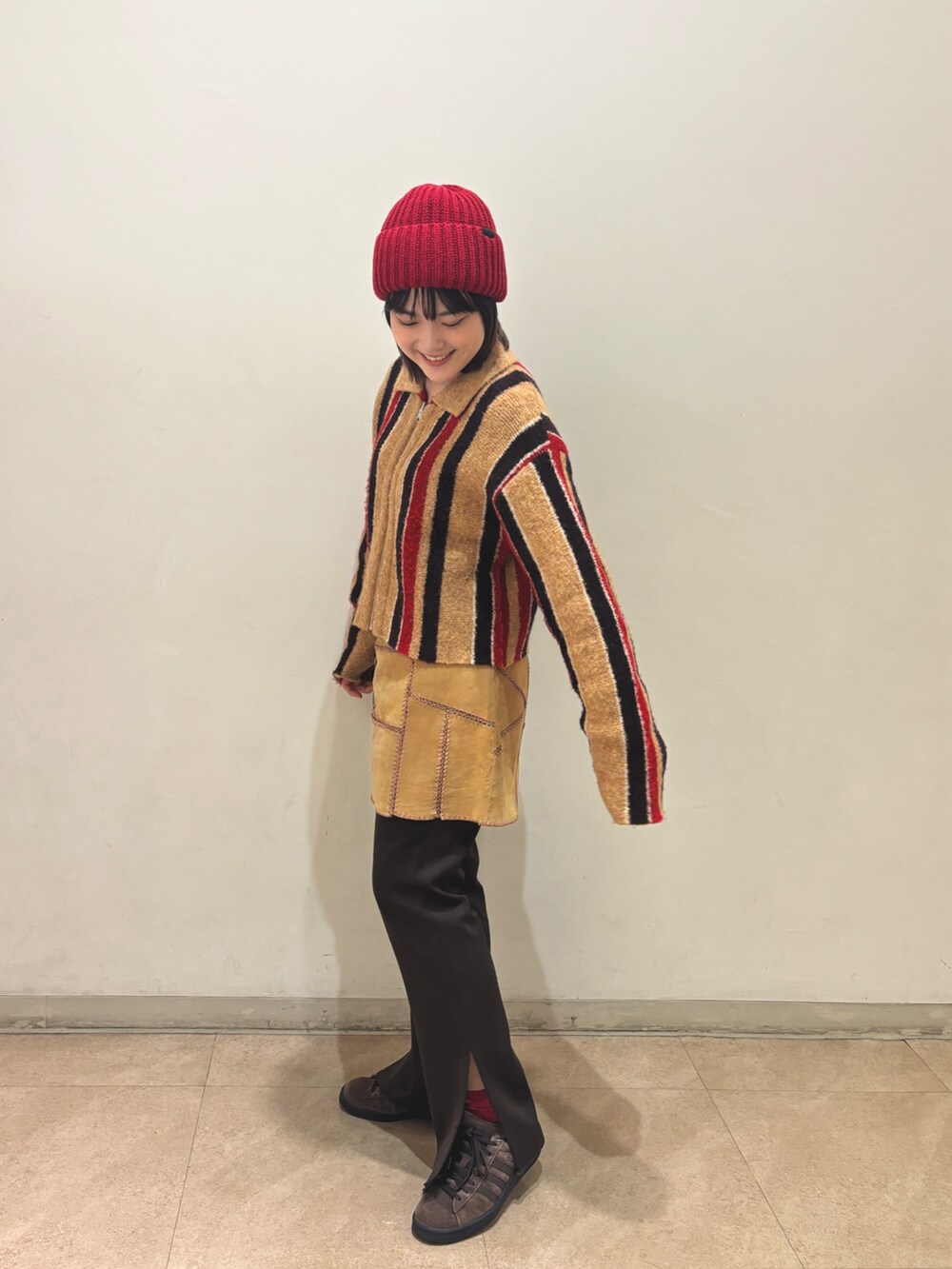 ベージュ系のカーディガン/ボレロ、ベージュ系のスカート、ブラウン系のスラックスを着用したレディースの秋コーディネートの2枚目の写真