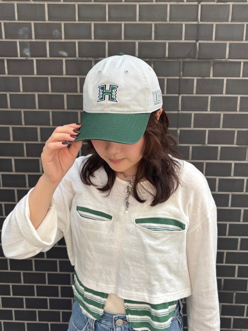 ブルー系のデニムスカート、グレー系のキャップを着用したレディースの夏コーディネートの2枚目の写真