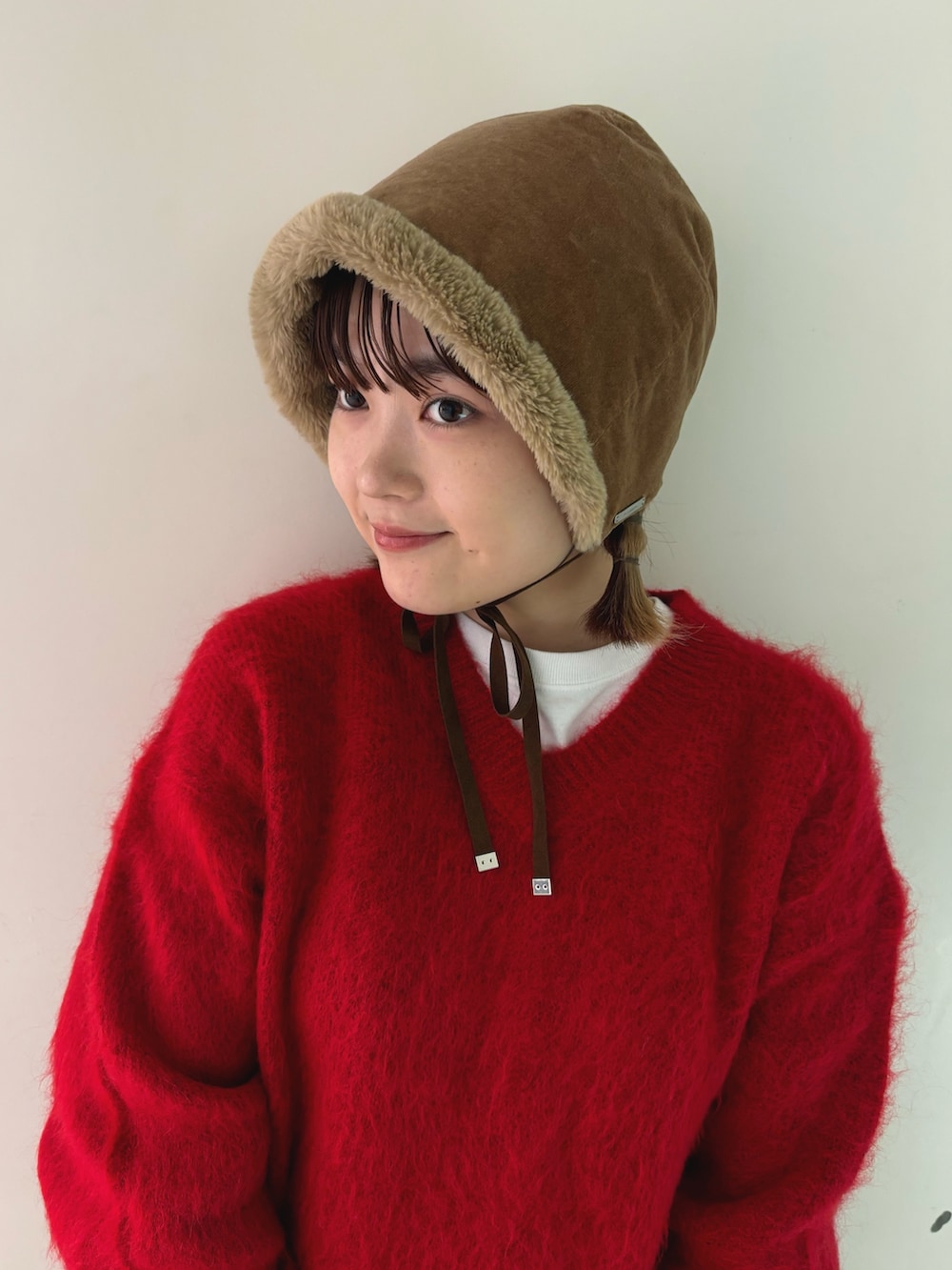 レッド系のニット/セーター、ホワイト系のTシャツ/カットソー、ブラウン系のその他パンツを着用したレディースの秋コーディネートの4枚目の写真