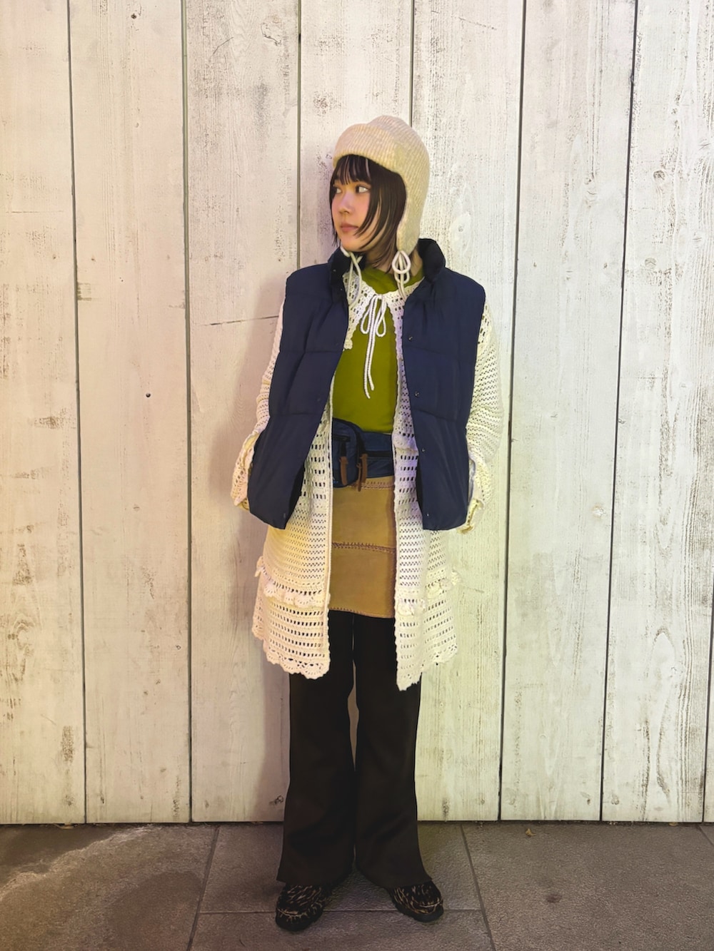 グリーン系のニット/セーター、ベージュ系のスカート、ブルー系のボディバッグ/ウエストポーチを着用したレディースの冬コーディネートの2枚目の写真