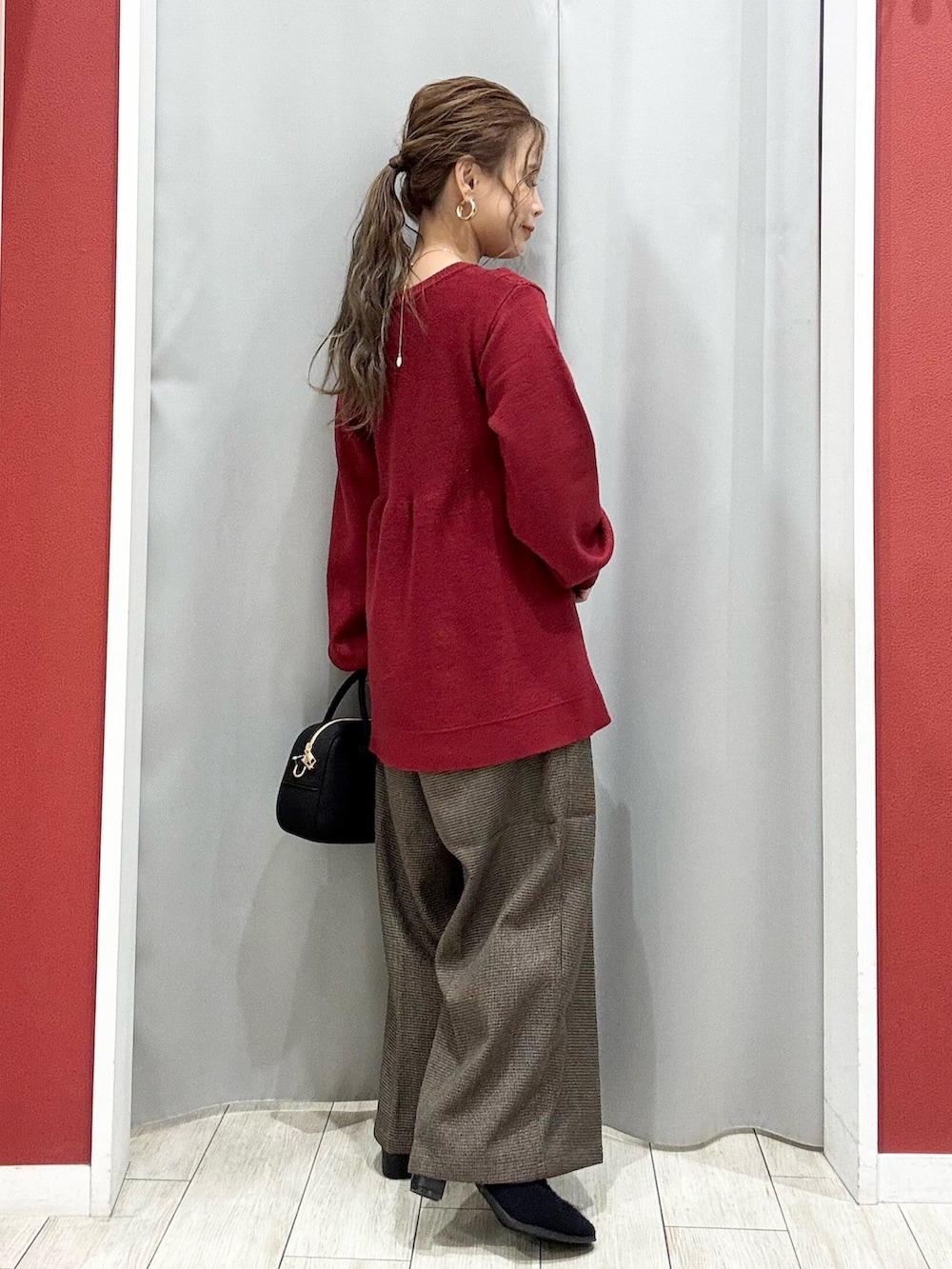 ベージュ系のダウンジャケット/コート、レッド系のニット/セーター、ベージュ系のその他パンツを着用したレディースの冬コーディネートの9枚目の写真