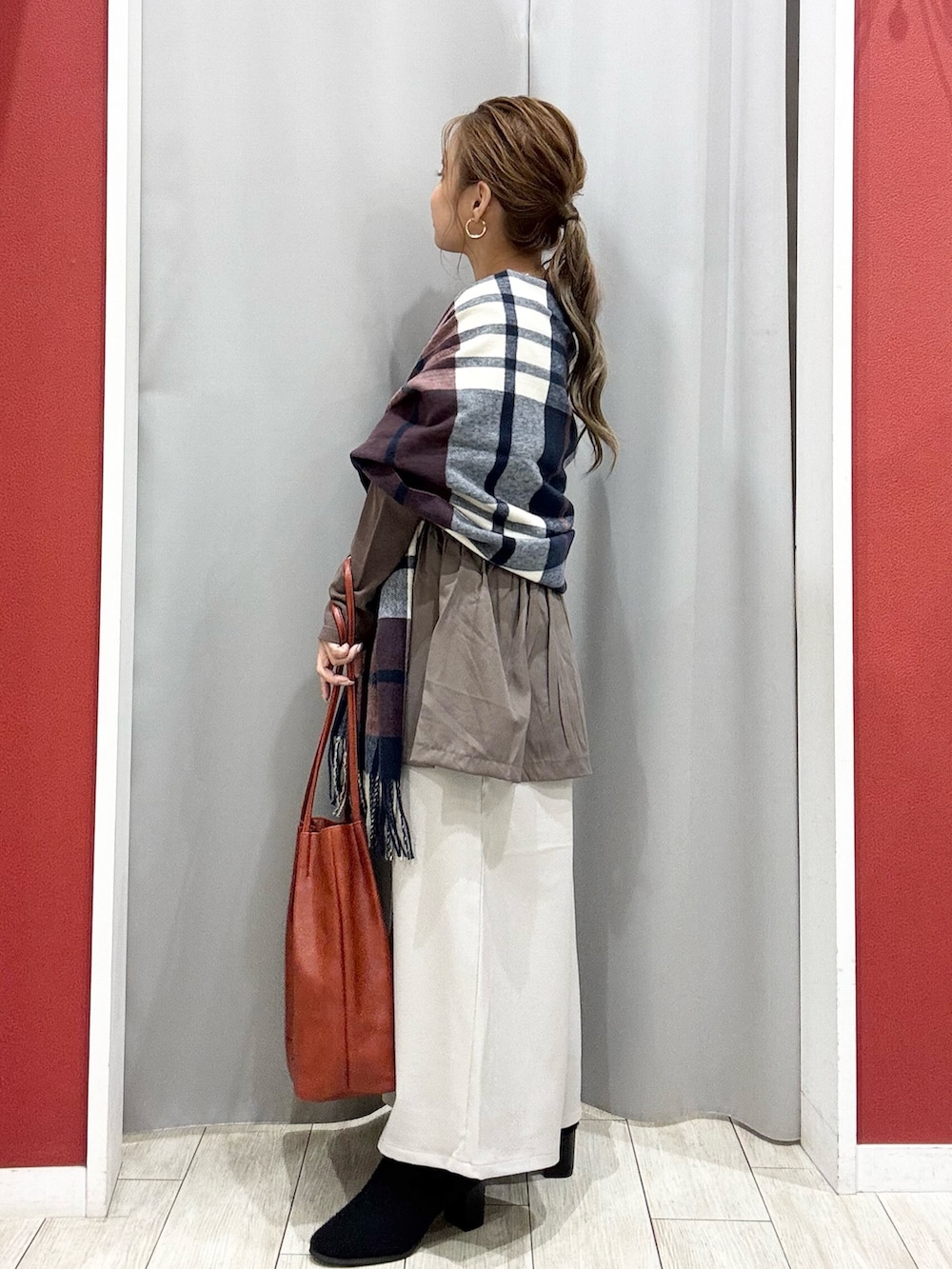 ブラウン系のニット/セーター、ベージュ系のその他パンツ、ブラック系のブーツを着用したレディースの秋コーディネートの3枚目の写真