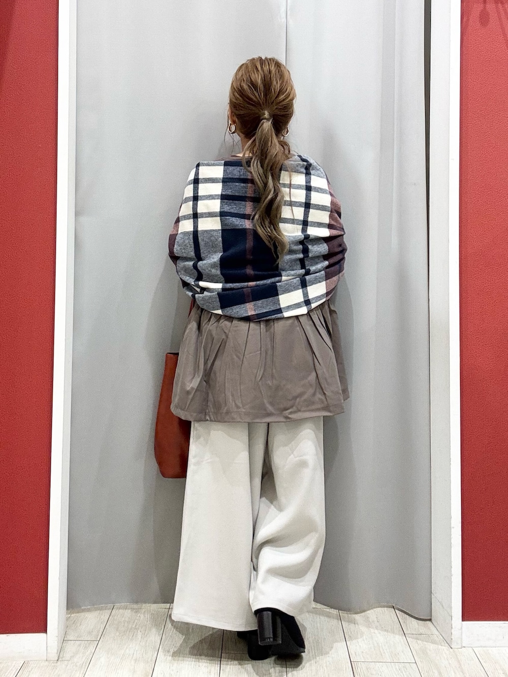 ブラウン系のニット/セーター、ベージュ系のその他パンツ、ブラック系のブーツを着用したレディースの秋コーディネートの5枚目の写真