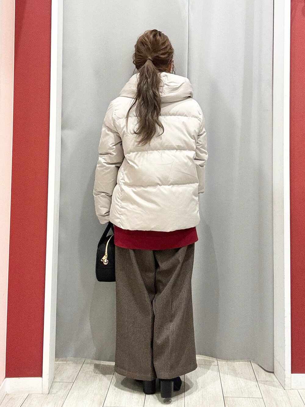 ベージュ系のダウンジャケット/コート、レッド系のニット/セーター、ベージュ系のその他パンツを着用したレディースの冬コーディネートの5枚目の写真