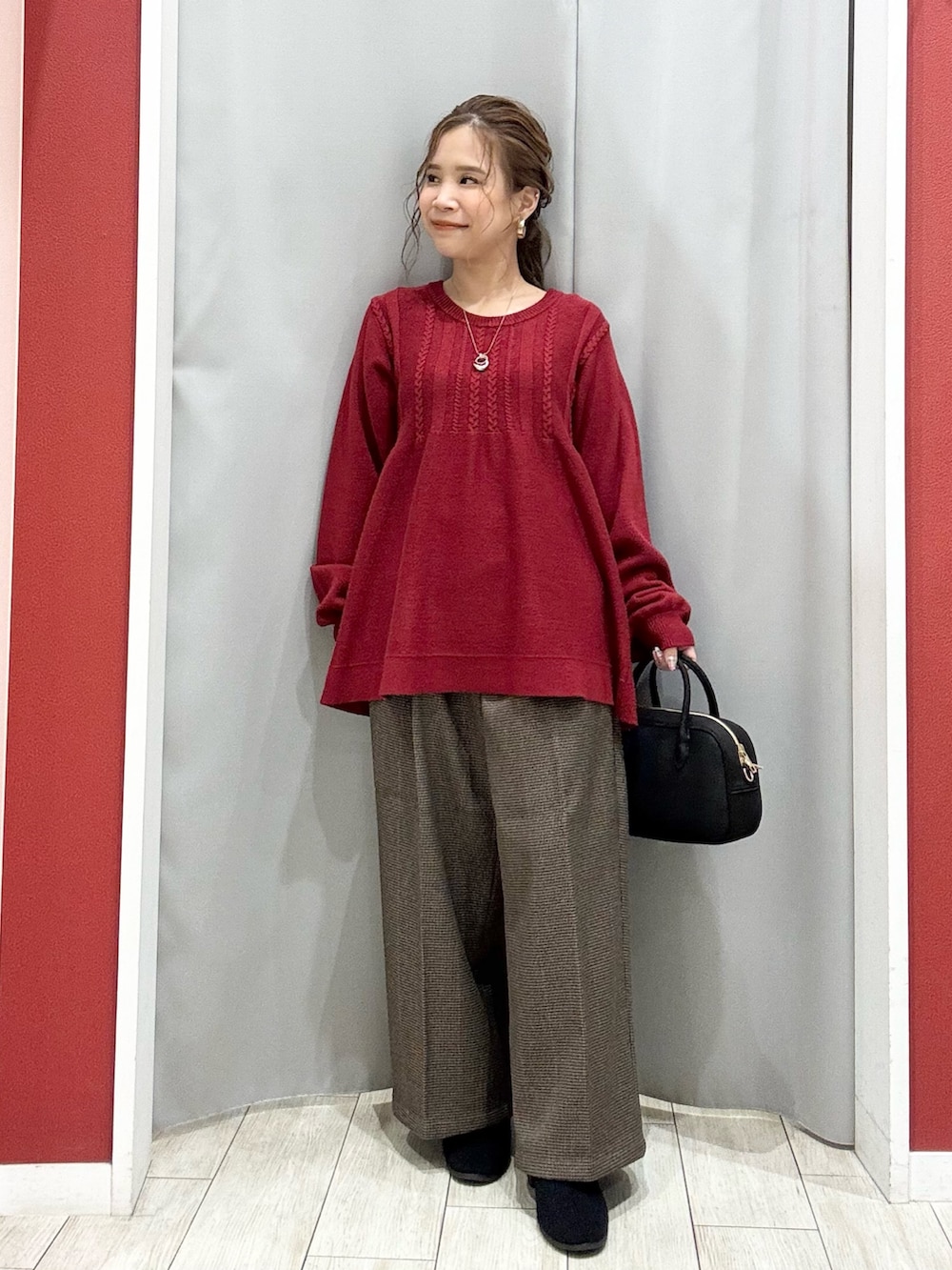 ベージュ系のダウンジャケット/コート、レッド系のニット/セーター、ベージュ系のその他パンツを着用したレディースの冬コーディネートの6枚目の写真