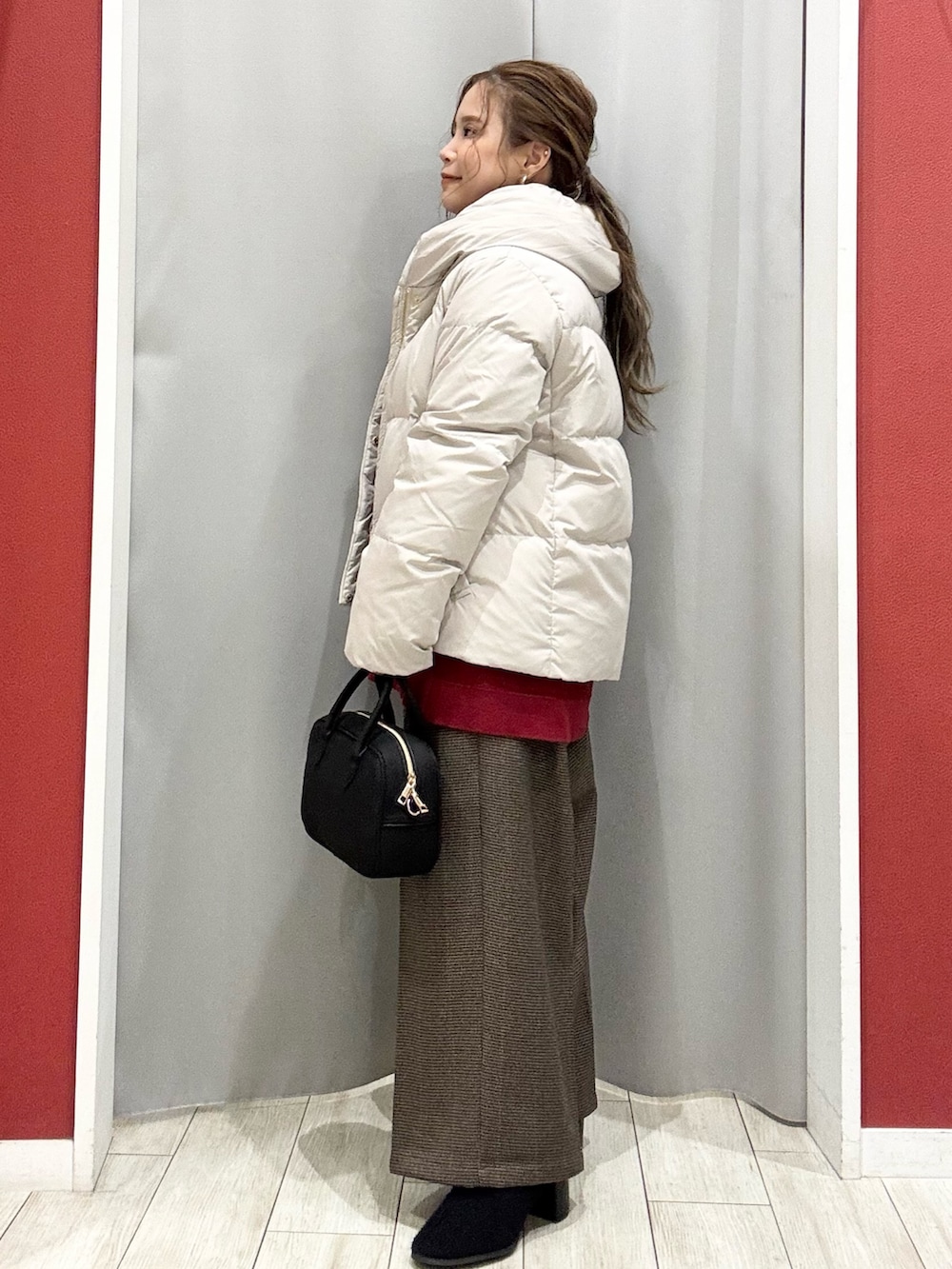 ベージュ系のダウンジャケット/コート、レッド系のニット/セーター、ベージュ系のその他パンツを着用したレディースの冬コーディネートの3枚目の写真