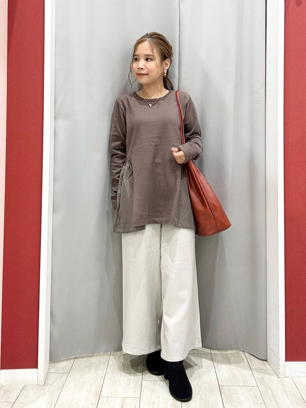 ブラウン系のニット/セーター、ベージュ系のその他パンツ、ブラック系のブーツを着用したレディースの秋コーディネートの6枚目の写真
