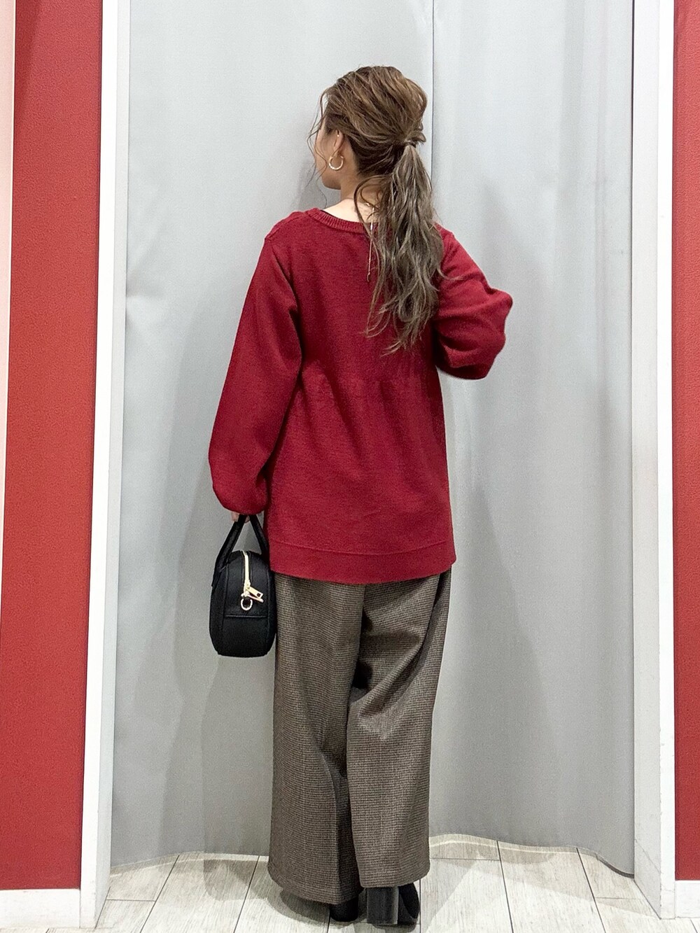 ベージュ系のダウンジャケット/コート、レッド系のニット/セーター、ベージュ系のその他パンツを着用したレディースの冬コーディネートの10枚目の写真