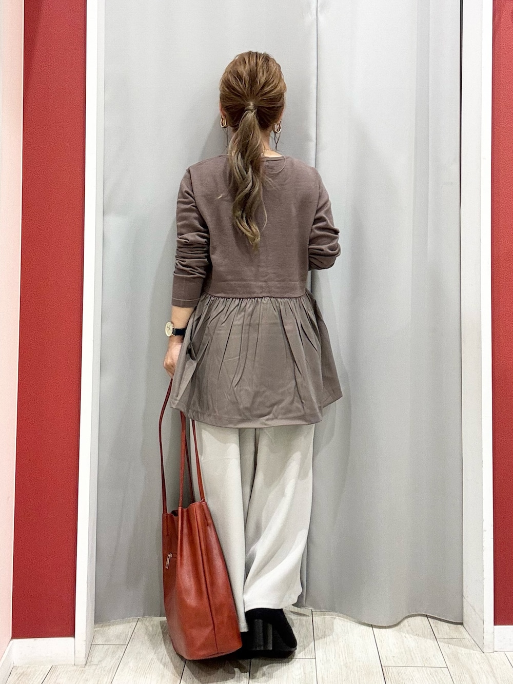 ブラウン系のニット/セーター、ベージュ系のその他パンツ、ブラック系のブーツを着用したレディースの秋コーディネートの10枚目の写真