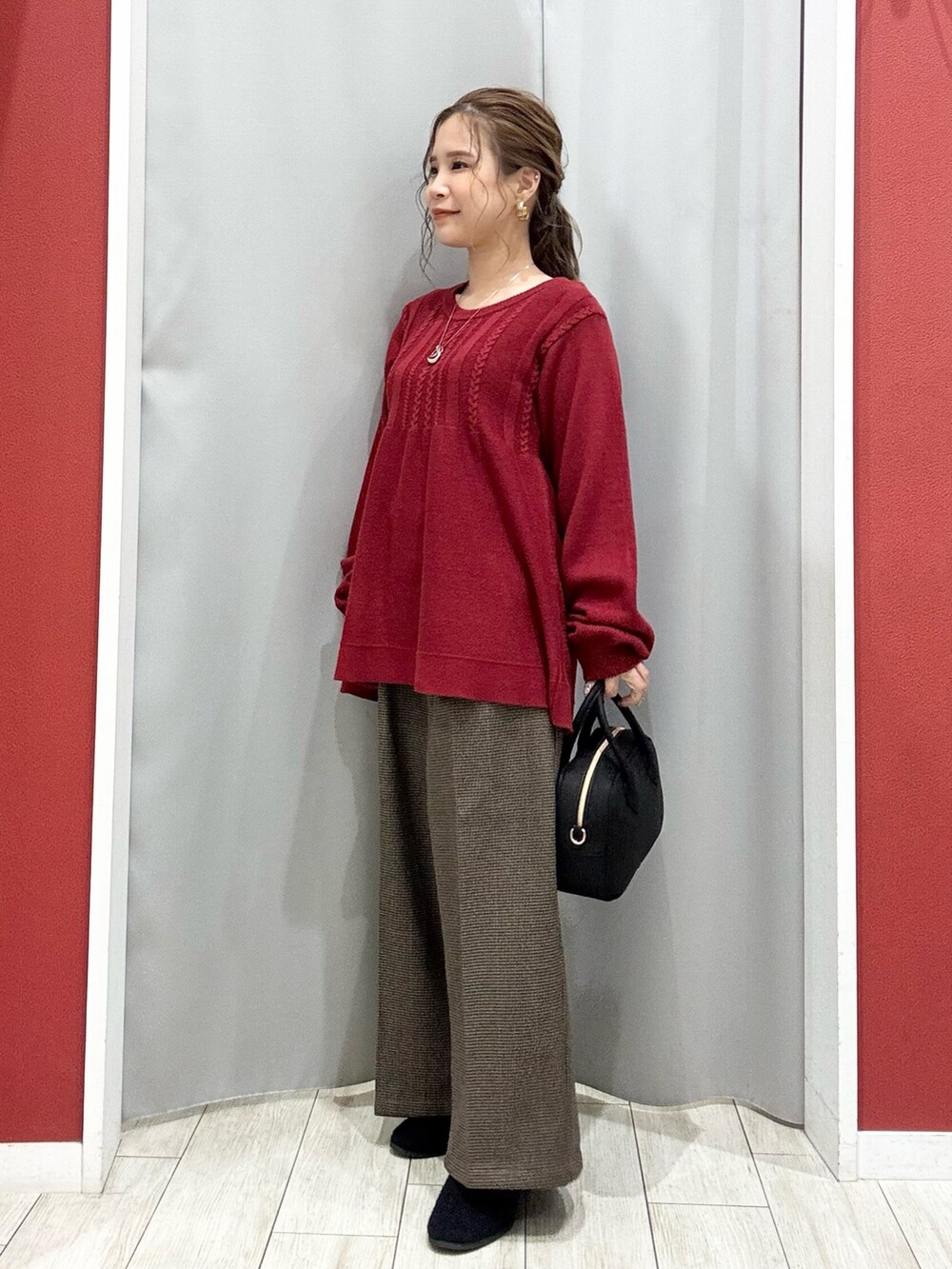 ベージュ系のダウンジャケット/コート、レッド系のニット/セーター、ベージュ系のその他パンツを着用したレディースの冬コーディネートの8枚目の写真