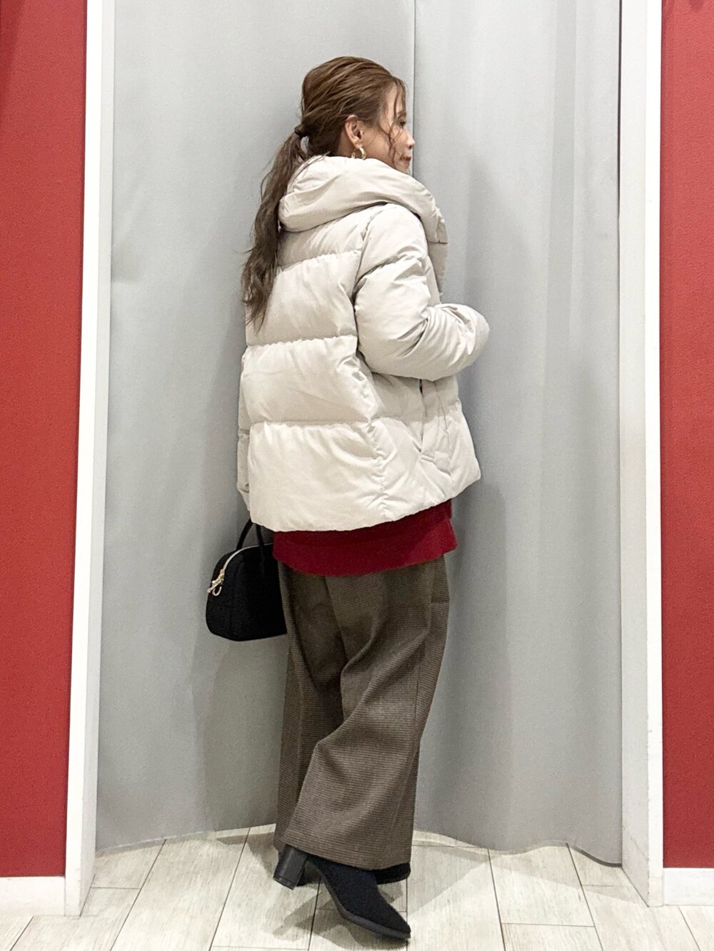 ベージュ系のダウンジャケット/コート、レッド系のニット/セーター、ベージュ系のその他パンツを着用したレディースの冬コーディネートの4枚目の写真