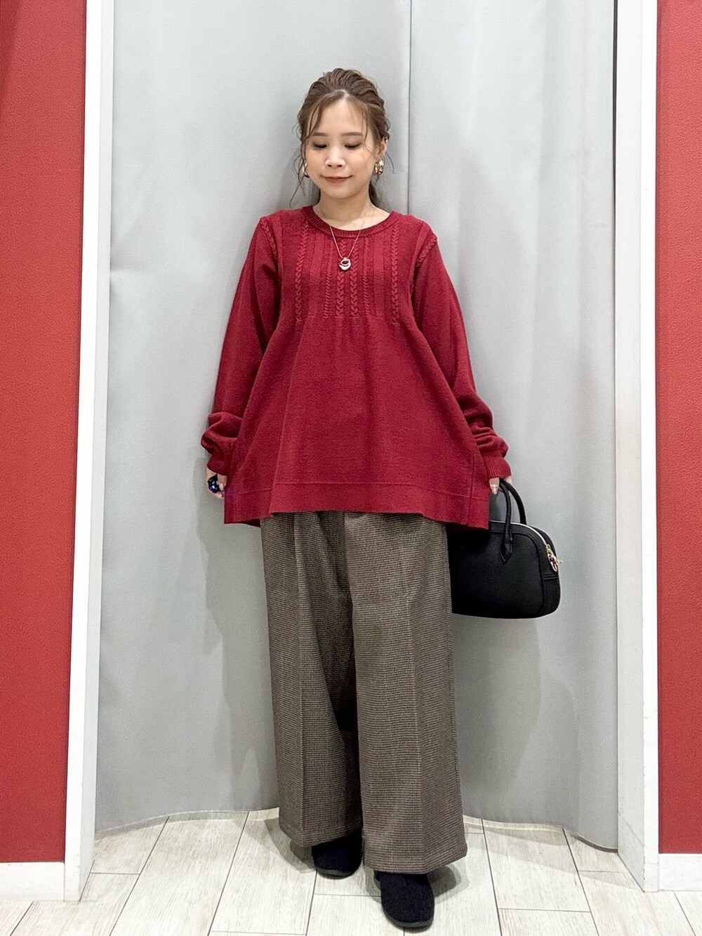 ベージュ系のダウンジャケット/コート、レッド系のニット/セーター、ベージュ系のその他パンツを着用したレディースの冬コーディネートの7枚目の写真