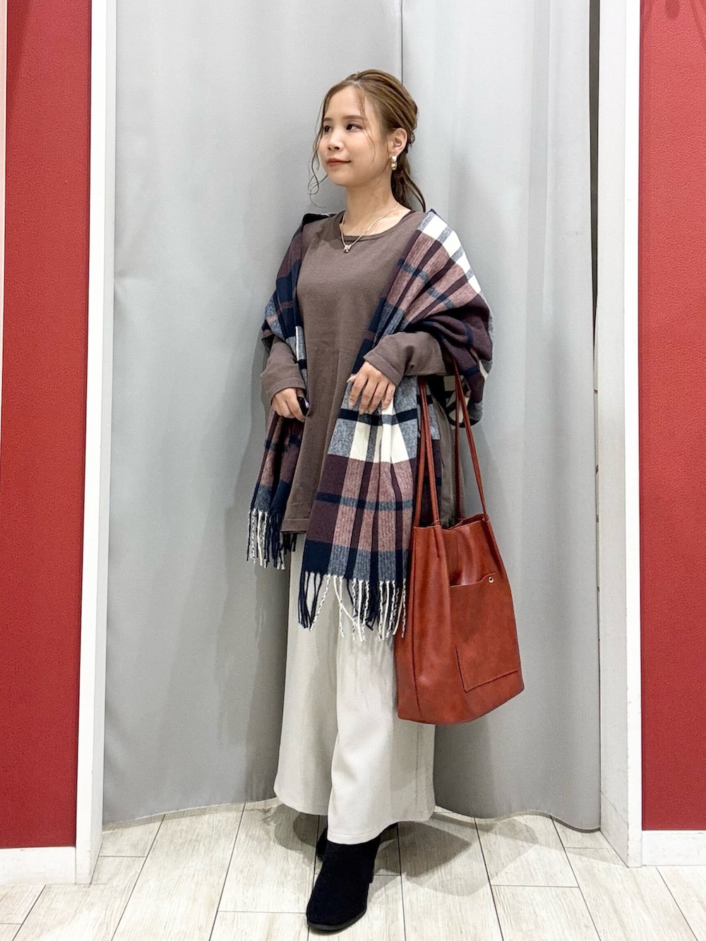 ブラウン系のニット/セーター、ベージュ系のその他パンツ、ブラック系のブーツを着用したレディースの秋コーディネートの2枚目の写真