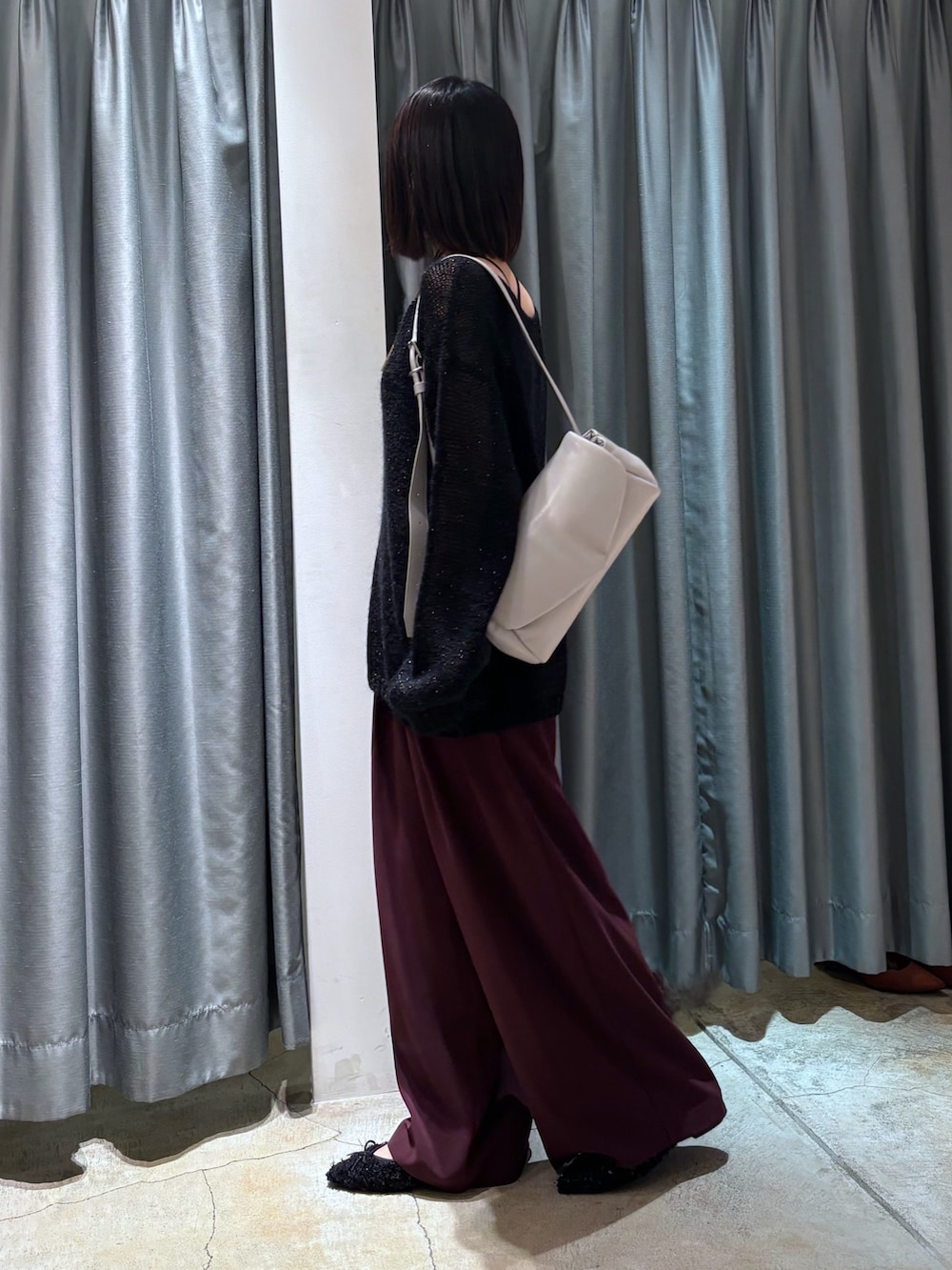 ブラック系のニット/セーター、レッド系のスラックス、グレー系のショルダーバッグを着用したレディースの秋コーディネートの2枚目の写真