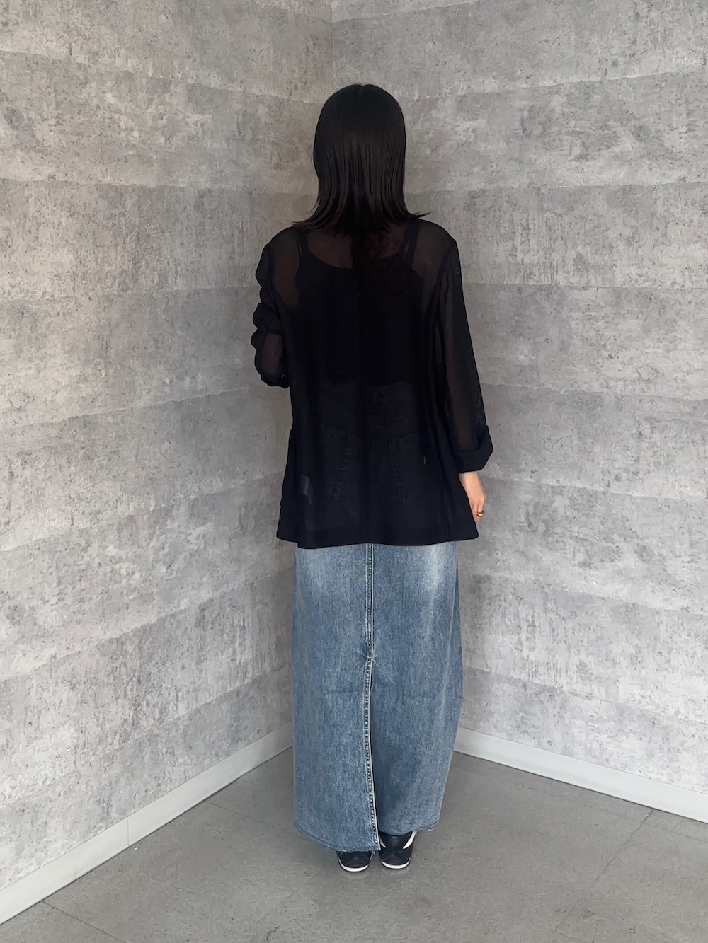 ブルー系のスカート、ブラック系のテーラードジャケット、ブラック系のシャツ/ブラウスを着用したレディースの冬コーディネートの2枚目の写真