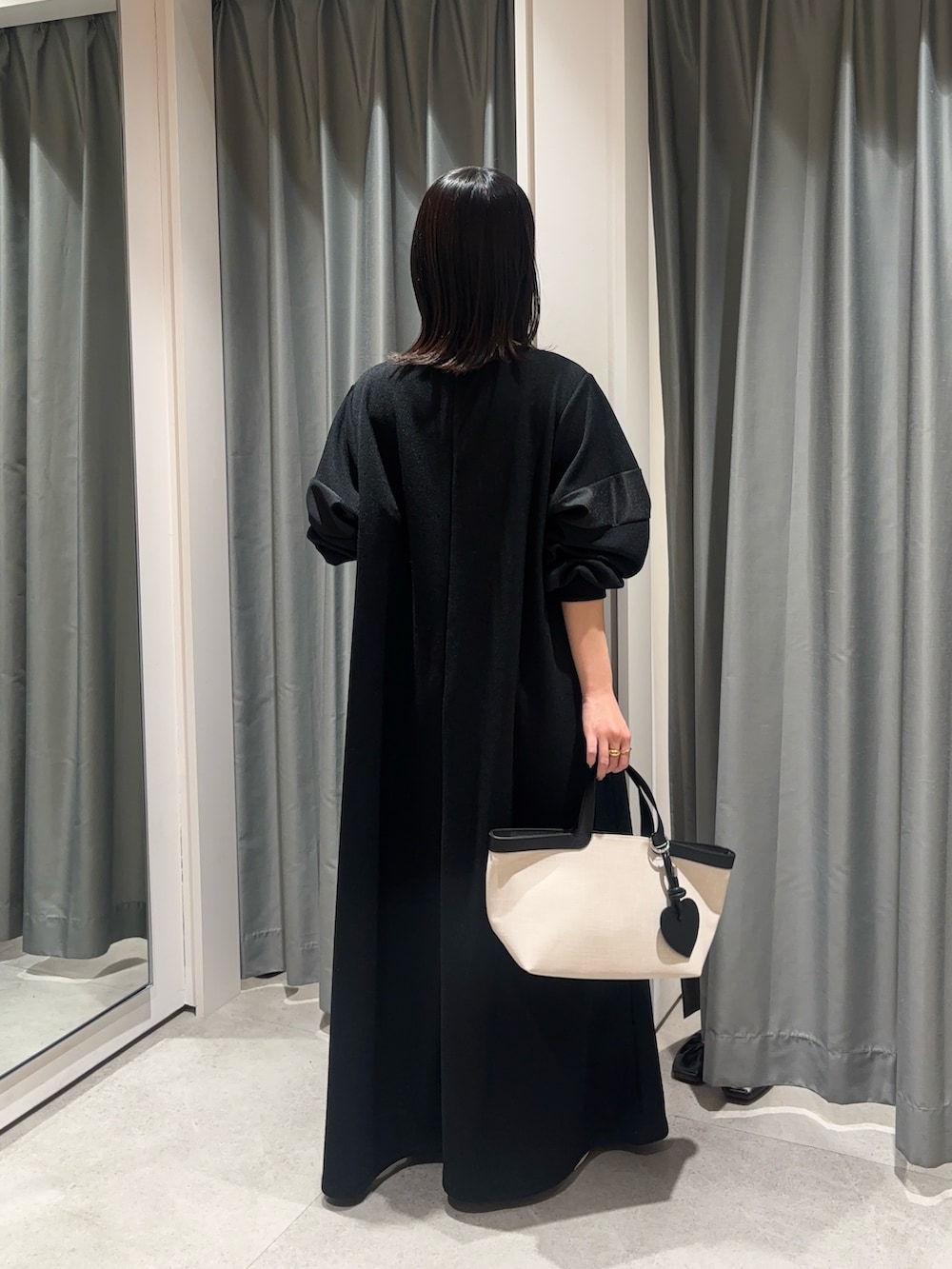 ブラック系のワンピース、ホワイト系のショルダーバッグを着用したレディースの春コーディネートの3枚目の写真