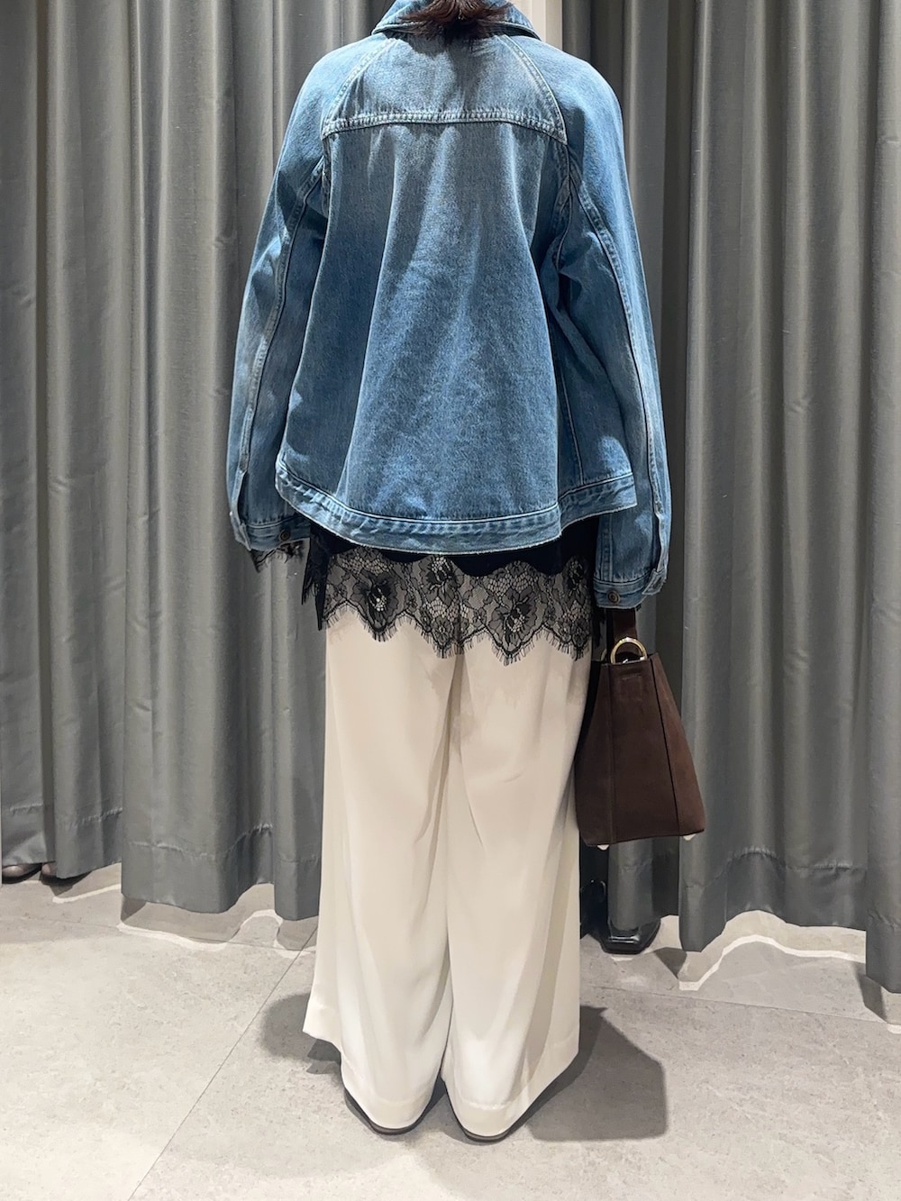 ホワイト系のスラックス、ブルー系のその他アウター、ブラック系のTシャツ/カットソーを着用したレディースの春コーディネートの3枚目の写真