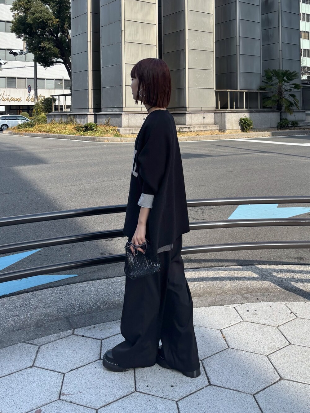 ブラック系のニット/セーター、ブラック系のその他パンツ、ブラック系のショルダーバッグを着用したレディースの冬コーディネートの3枚目の写真