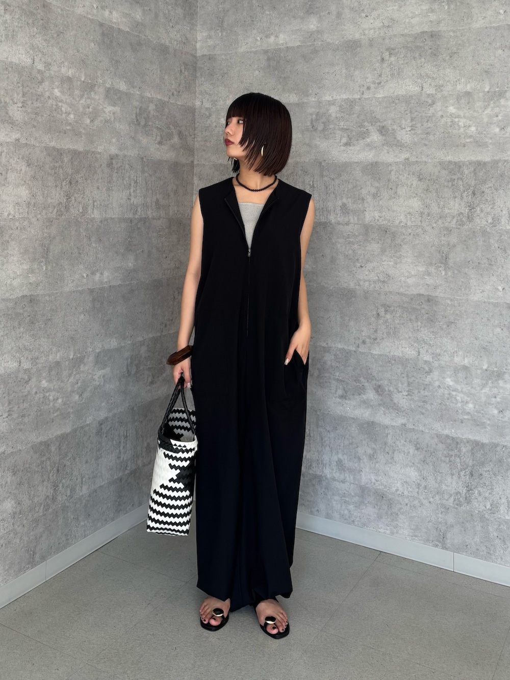 ブラック系のつなぎ/オールインワン、グレー系のタンクトップ、ブラック系のショルダーバッグを着用したレディースの夏コーディネートの2枚目の写真