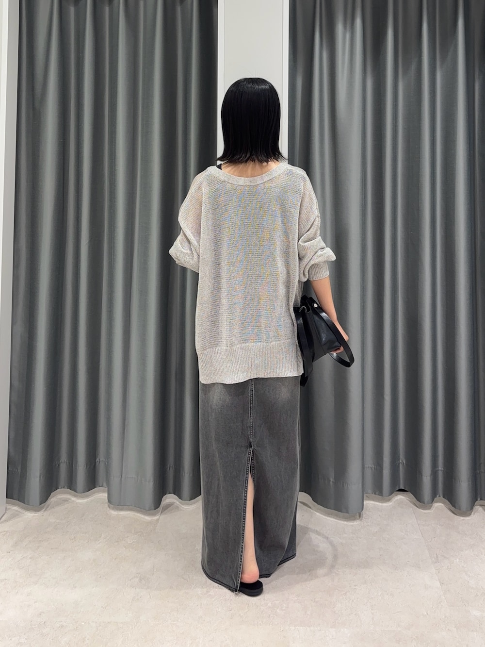 ブラック系のスカート、グレー系のカーディガン/ボレロ、グレー系のタンクトップを着用したレディースの夏コーディネートの3枚目の写真