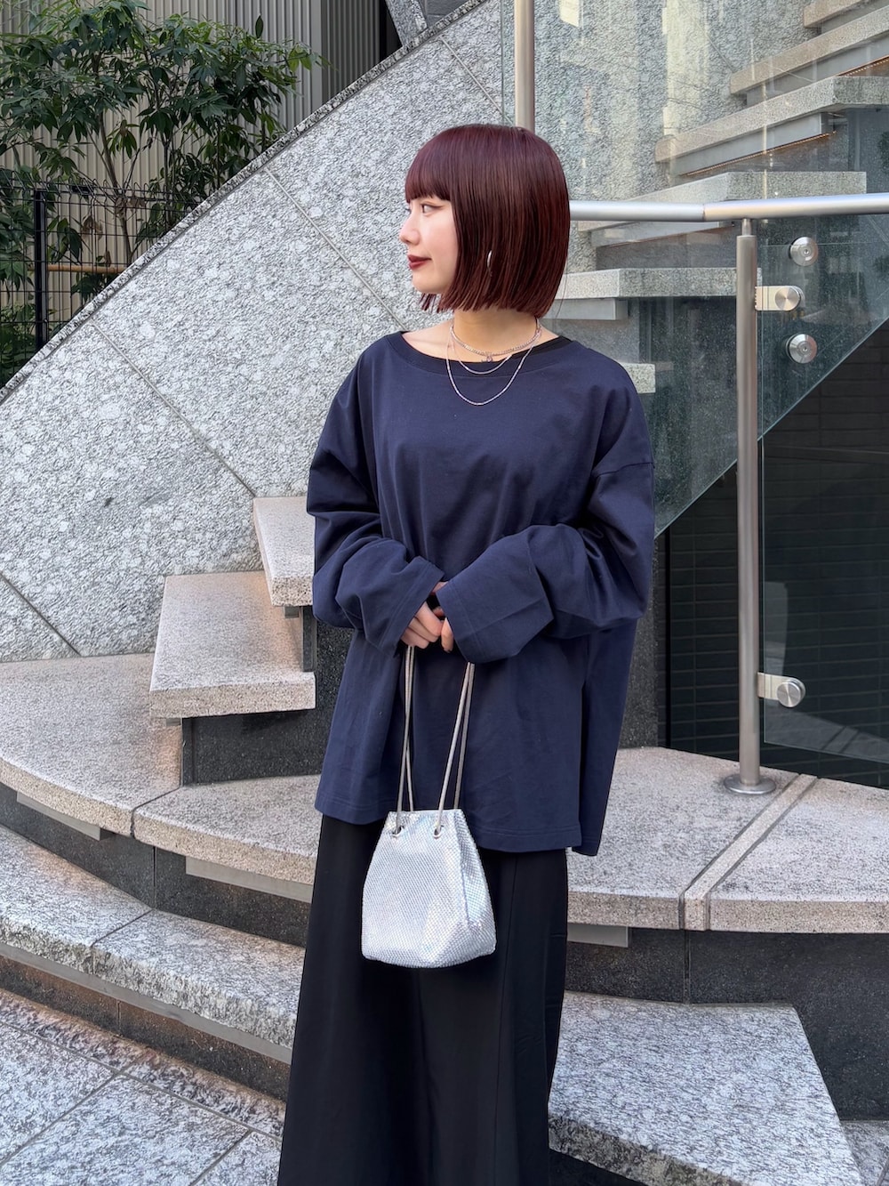 ブラック系のスカート、ブルー系のTシャツ/カットソー、シルバー系のショルダーバッグを着用したレディースの冬コーディネートの5枚目の写真