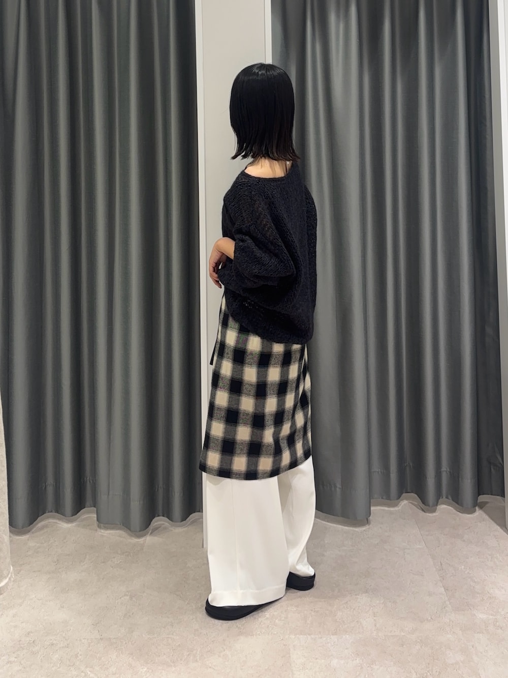 ブラック系のシャツ/ブラウス、グレー系のニット/セーター、ホワイト系のスラックスを着用したレディースの秋コーディネートの4枚目の写真
