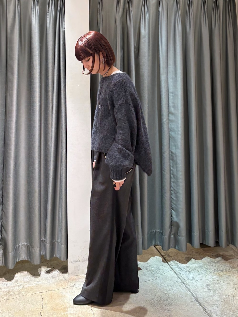 グレー系のニット/セーター、グレー系のその他パンツ、ホワイト系のTシャツ/カットソーを着用したレディースの冬コーディネートの4枚目の写真