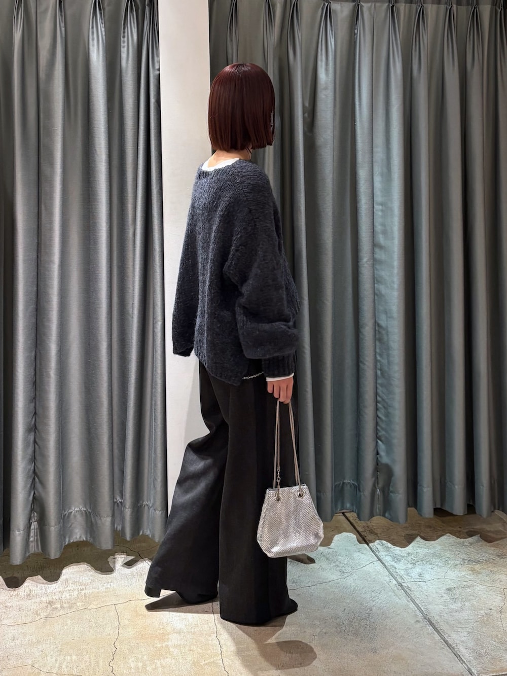 グレー系のニット/セーター、グレー系のその他パンツ、ホワイト系のTシャツ/カットソーを着用したレディースの冬コーディネートの2枚目の写真
