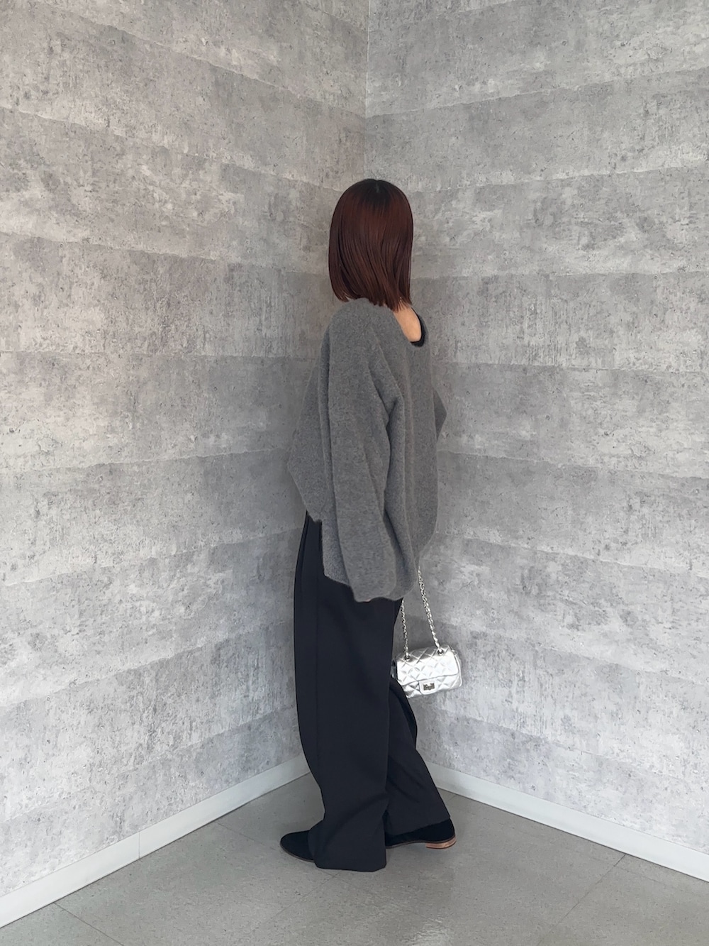 ブラック系のその他パンツ、シルバー系のショルダーバッグ、グレー系のニット/セーターを着用したレディースの秋コーディネートの2枚目の写真