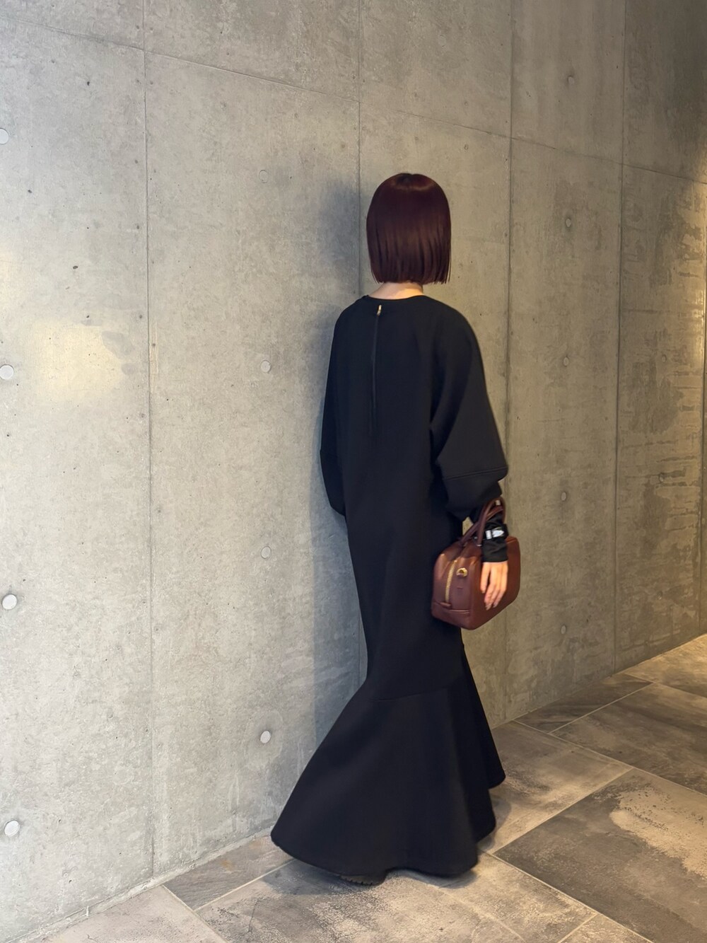 ブラック系のワンピース、ブラック系のTシャツ/カットソー、ブラウン系のショルダーバッグを着用したレディースの冬コーディネートの3枚目の写真