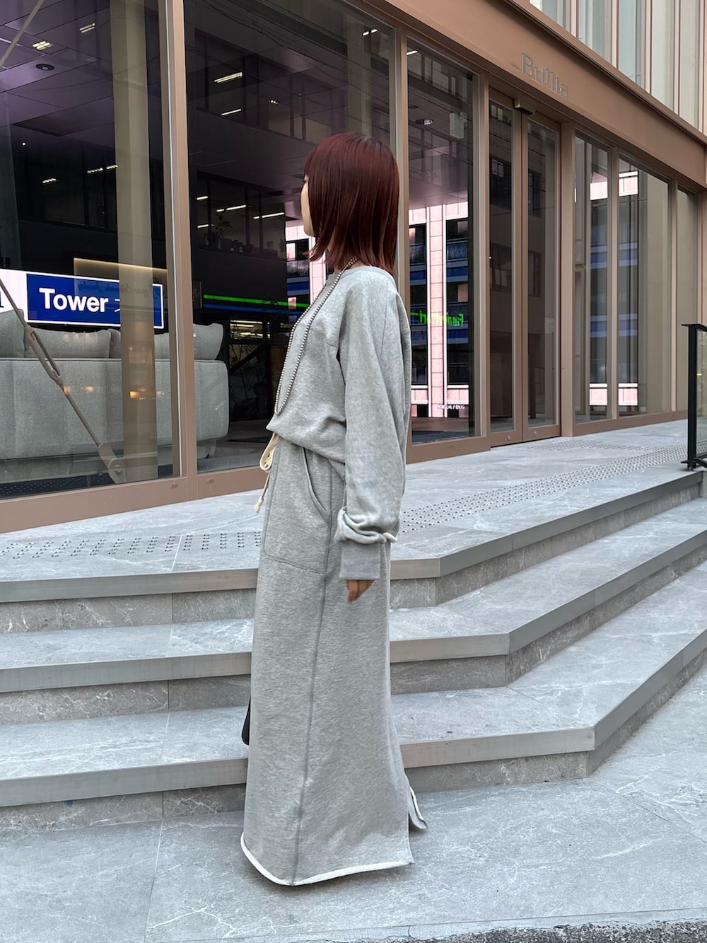 グレー系のスカート、グレー系のスウェット、ブラック系のショルダーバッグを着用したレディースの秋コーディネートの2枚目の写真