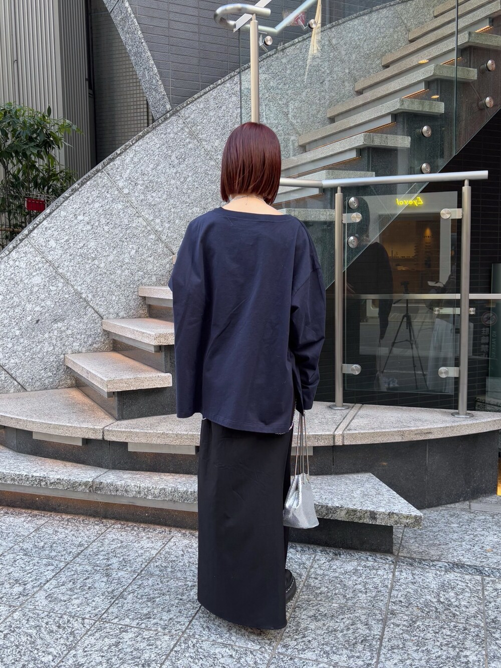 ブラック系のスカート、ブルー系のTシャツ/カットソー、シルバー系のショルダーバッグを着用したレディースの冬コーディネートの4枚目の写真