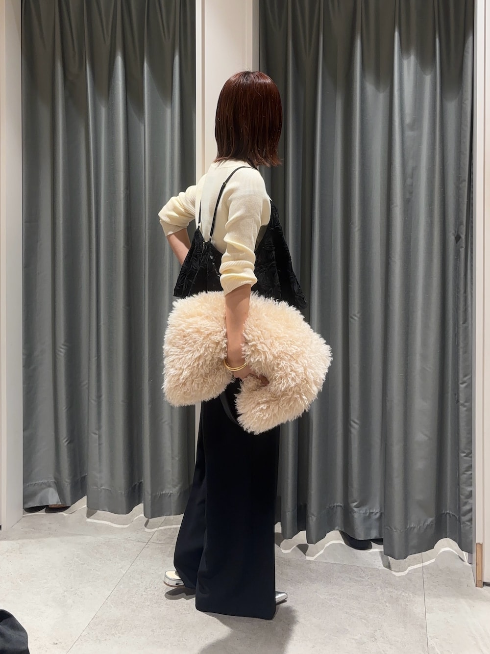 ブラック系のスラックス、ブラック系のシャツ/ブラウス、ホワイト系のニット/セーターを着用したレディースの秋コーディネートの2枚目の写真