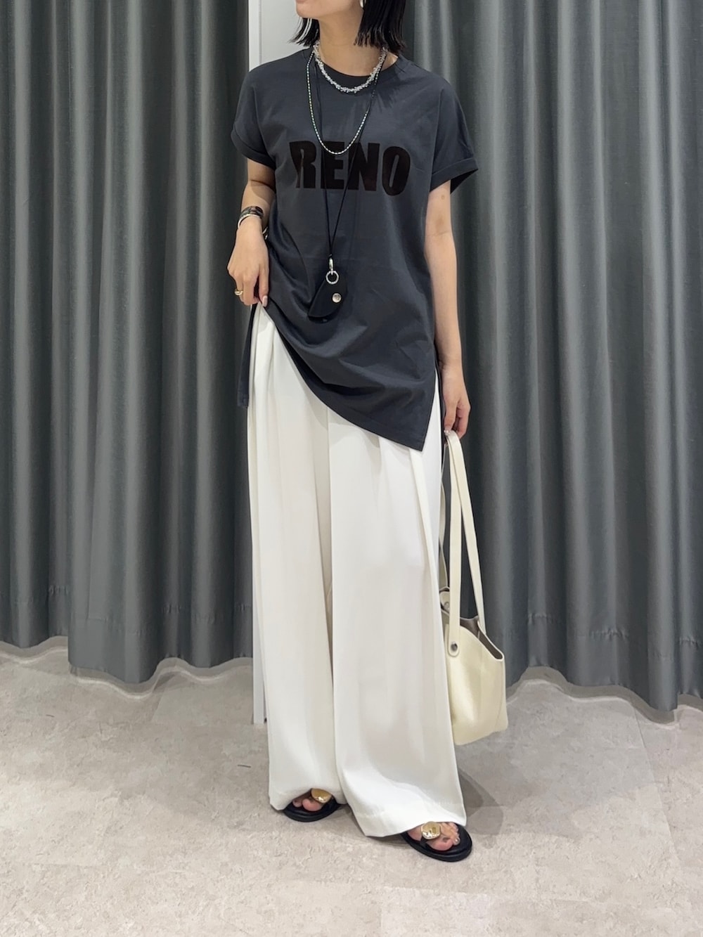 グレー系のTシャツ/カットソー、ホワイト系のスラックス、ブラック系のサンダルを着用したレディースの夏コーディネートの2枚目の写真