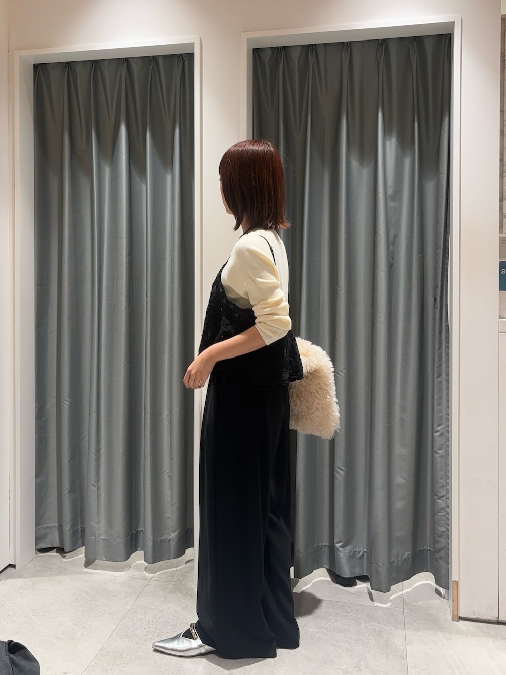 ブラック系のスラックス、ブラック系のシャツ/ブラウス、ホワイト系のニット/セーターを着用したレディースの秋コーディネートの3枚目の写真