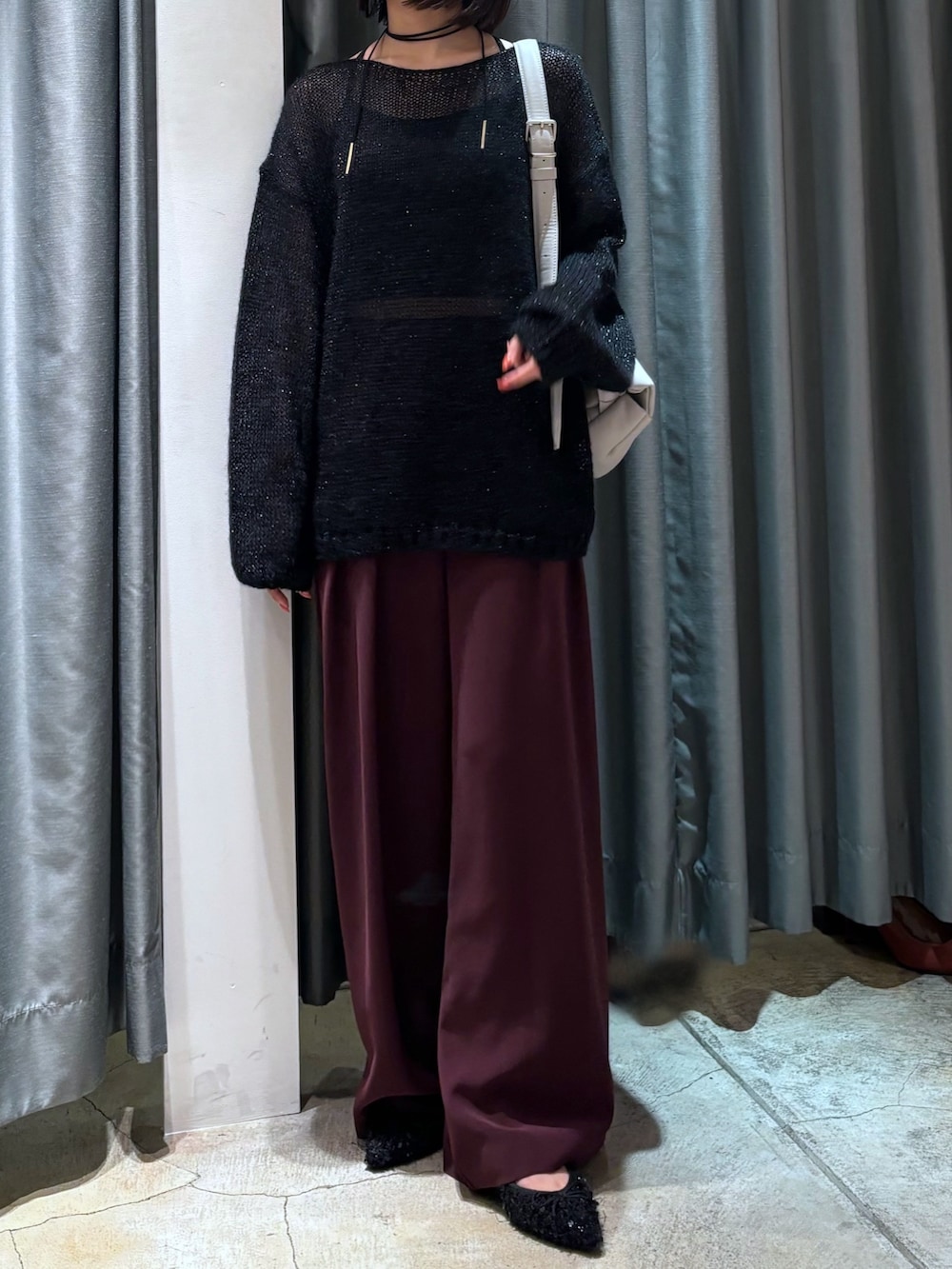 ブラック系のニット/セーター、レッド系のスラックス、グレー系のショルダーバッグを着用したレディースの秋コーディネートの4枚目の写真