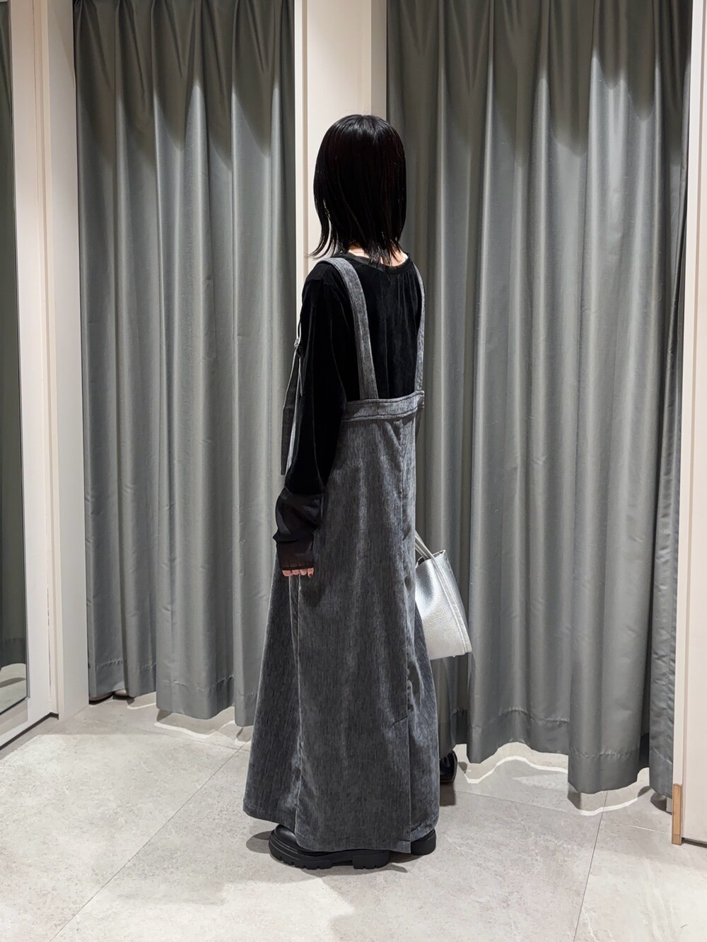 グレー系のワンピース、ブラック系のTシャツ/カットソー、シルバー系のハンドバッグを着用したレディースの冬コーディネートの3枚目の写真