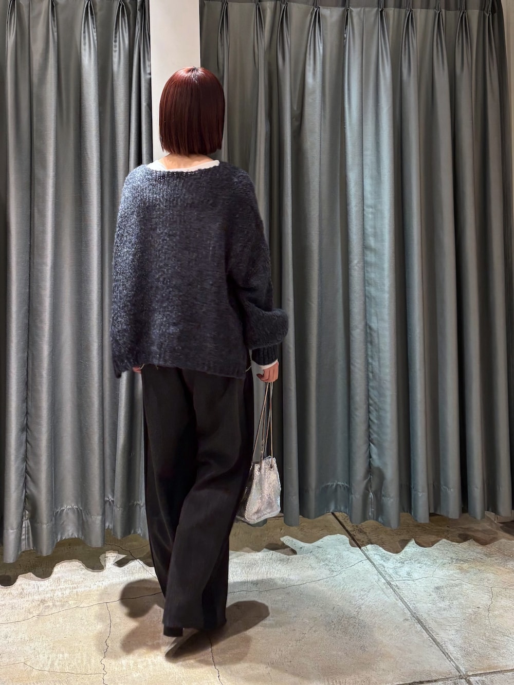グレー系のニット/セーター、グレー系のその他パンツ、ホワイト系のTシャツ/カットソーを着用したレディースの冬コーディネートの3枚目の写真