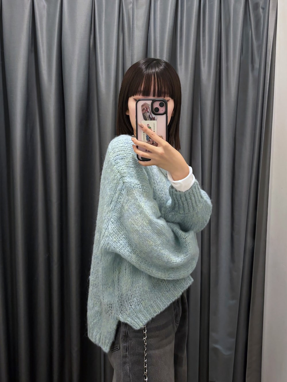 ブルー系のニット/セーター、ブラック系のデニムパンツ、ホワイト系のTシャツ/カットソーを着用したレディースの秋コーディネートの2枚目の写真