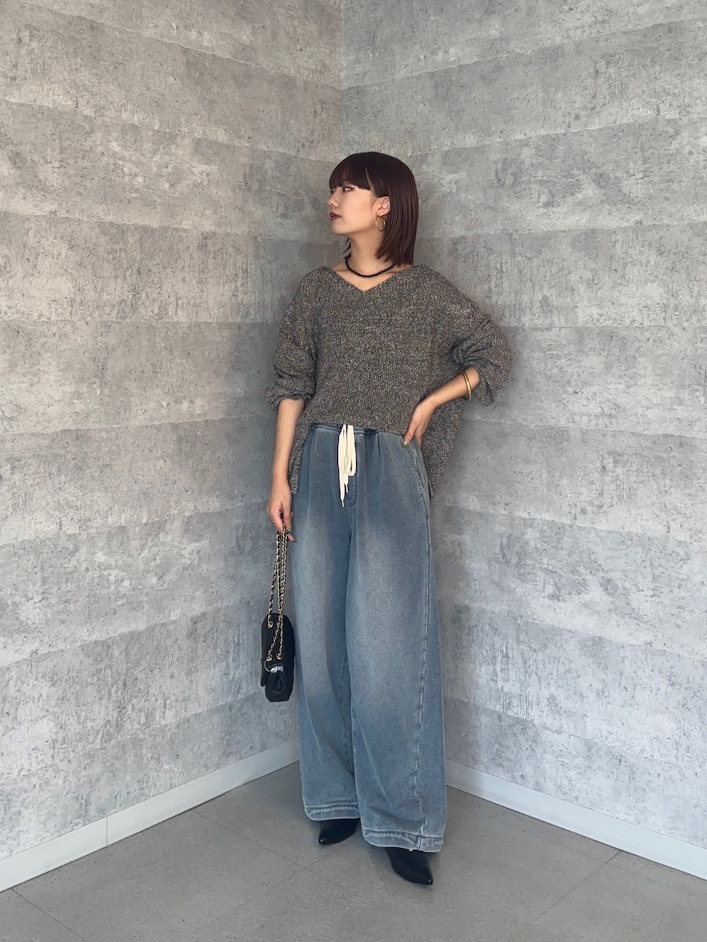 ブルー系のその他パンツ、グレー系のニット/セーター、ブラック系のショルダーバッグを着用したレディースの秋コーディネートの2枚目の写真