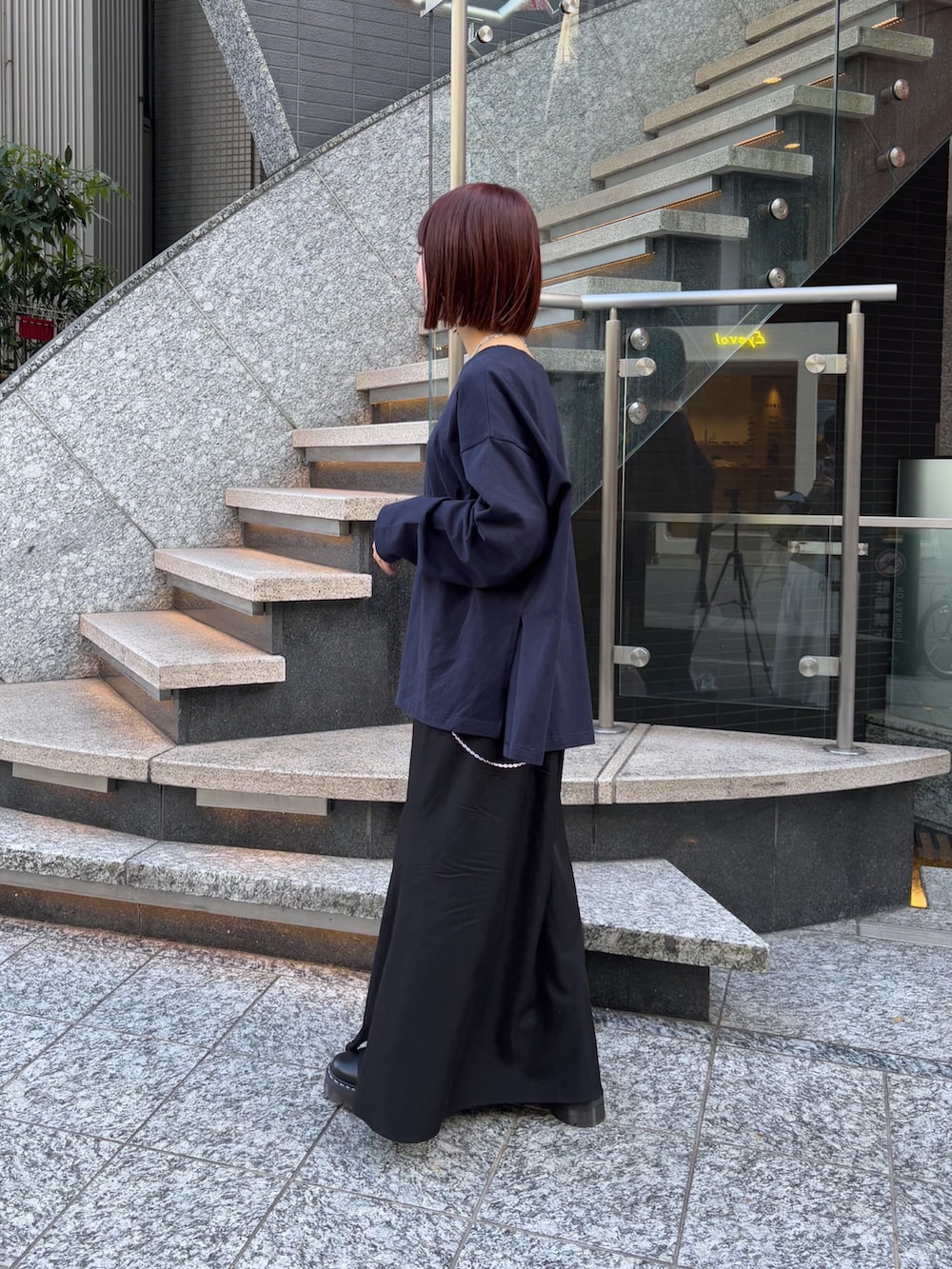ブラック系のスカート、ブルー系のTシャツ/カットソー、シルバー系のショルダーバッグを着用したレディースの冬コーディネートの3枚目の写真
