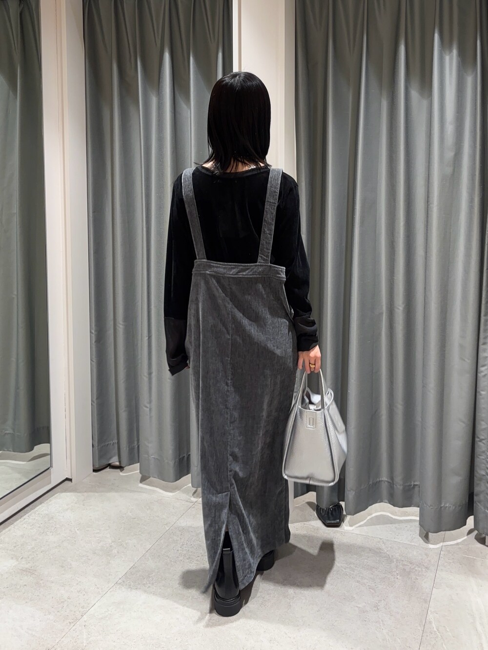 グレー系のワンピース、ブラック系のTシャツ/カットソー、シルバー系のハンドバッグを着用したレディースの冬コーディネートの5枚目の写真
