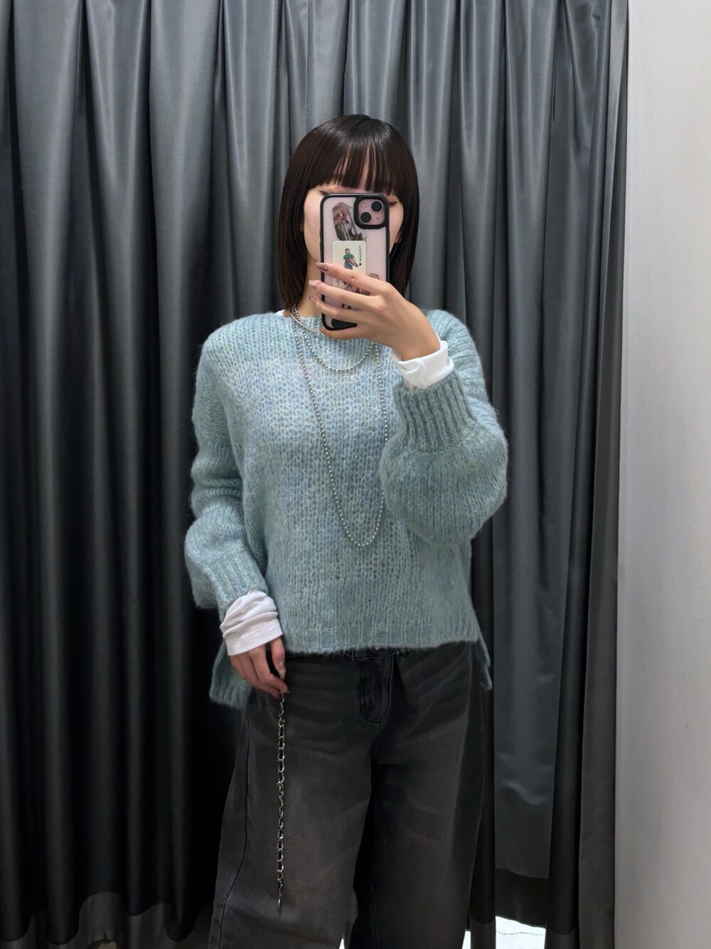 ブルー系のニット/セーター、ブラック系のデニムパンツ、ホワイト系のTシャツ/カットソーを着用したレディースの秋コーディネートの7枚目の写真