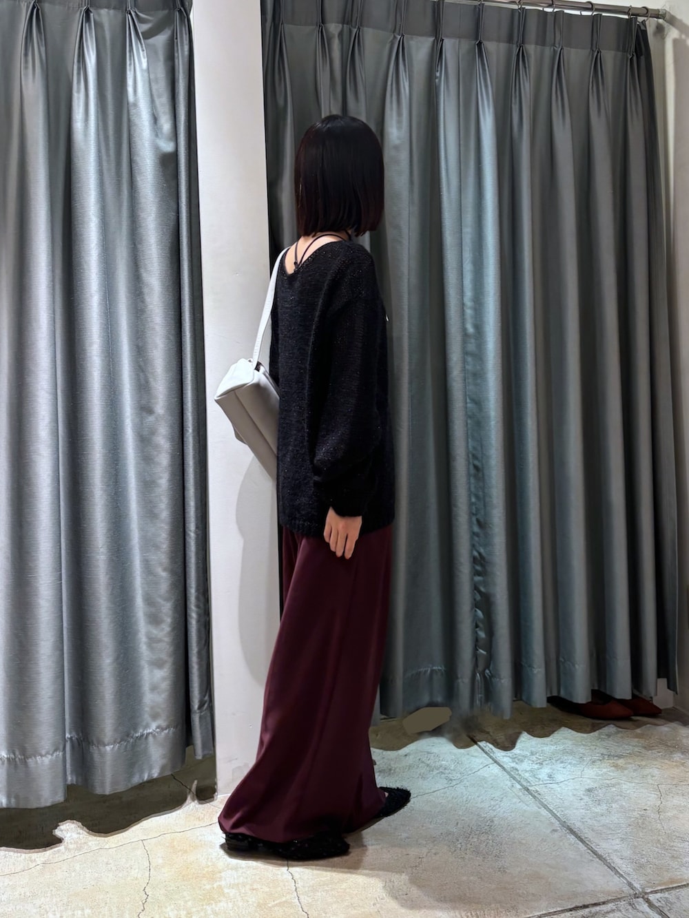 ブラック系のニット/セーター、レッド系のスラックス、グレー系のショルダーバッグを着用したレディースの秋コーディネートの3枚目の写真